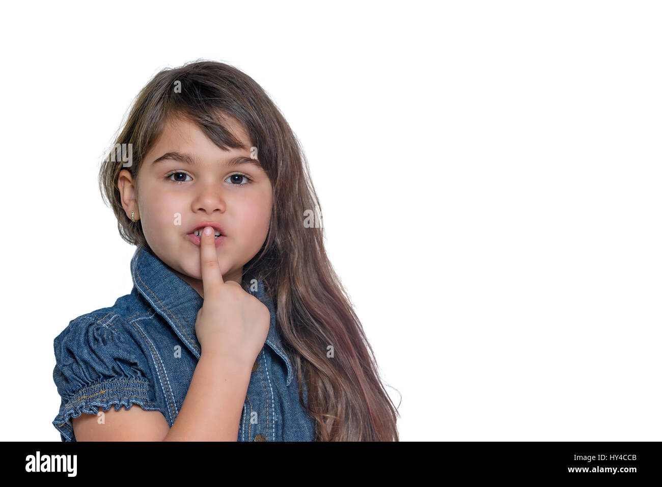 Portrait de petite fille aux cheveux longs brunette gesturing chut isolé sur le fond blanc. Banque D'Images