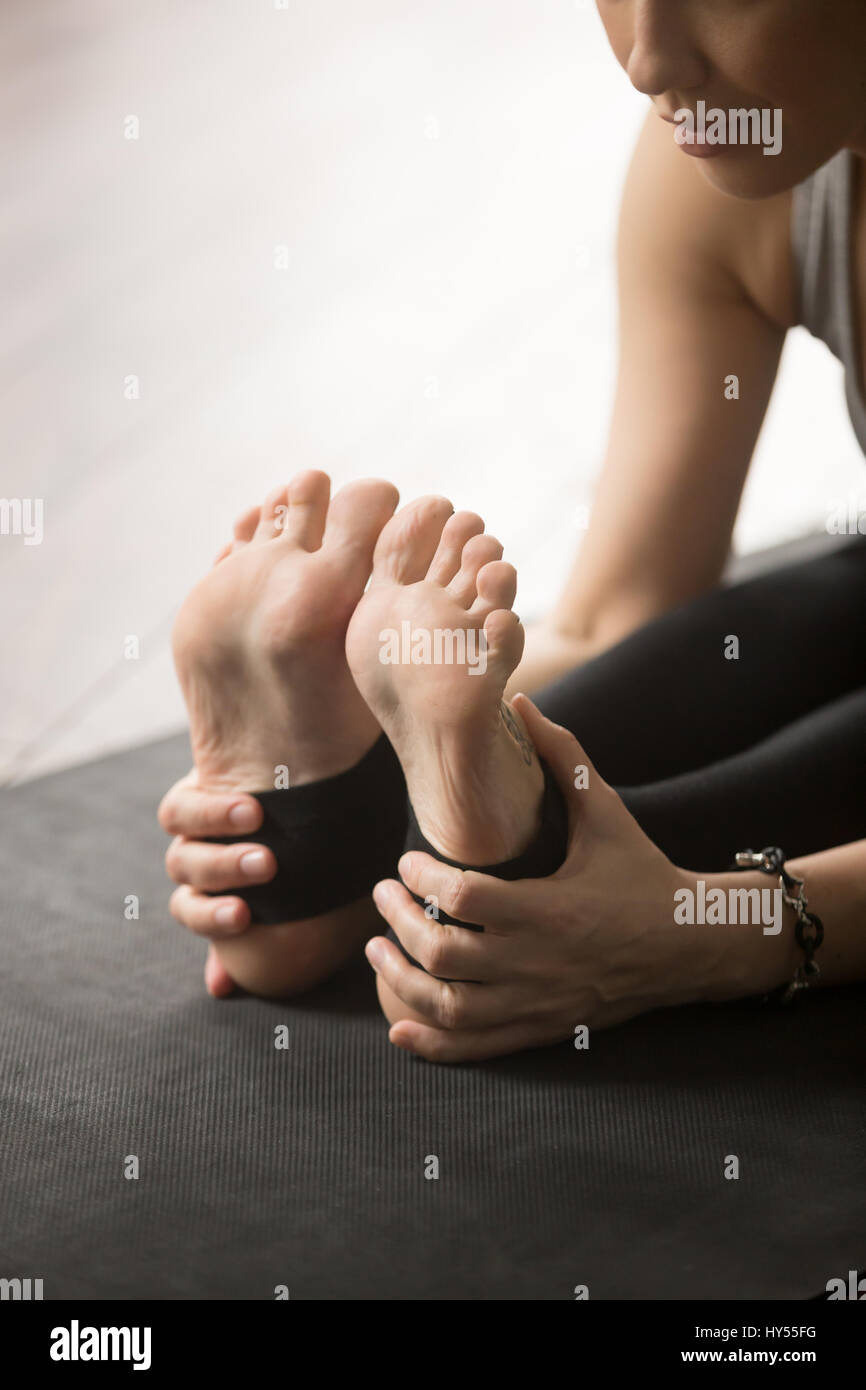 Young attractive sporty femme assise vers l'avant, studio, fermer Banque D'Images