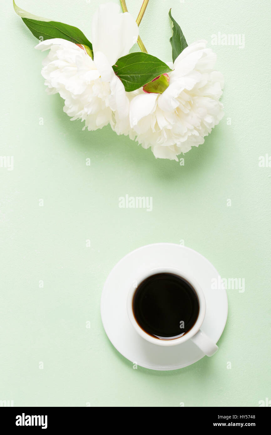 Tasse de café et de fleurs (pivoines) sur le tableau vert clair. Banque D'Images