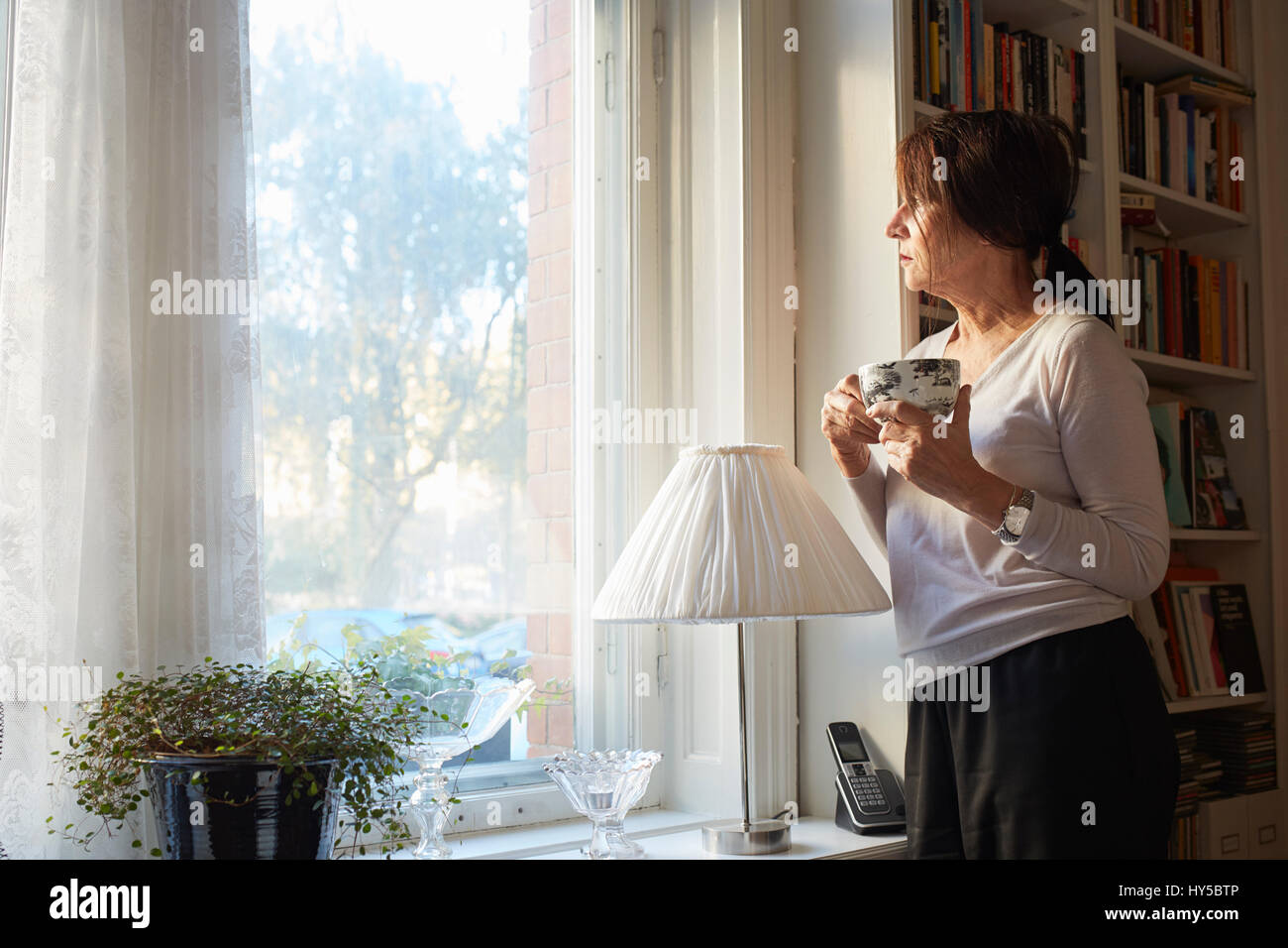 La Suède, la femme à la fenêtre, par l'intermédiaire de holding Coffee cup Banque D'Images