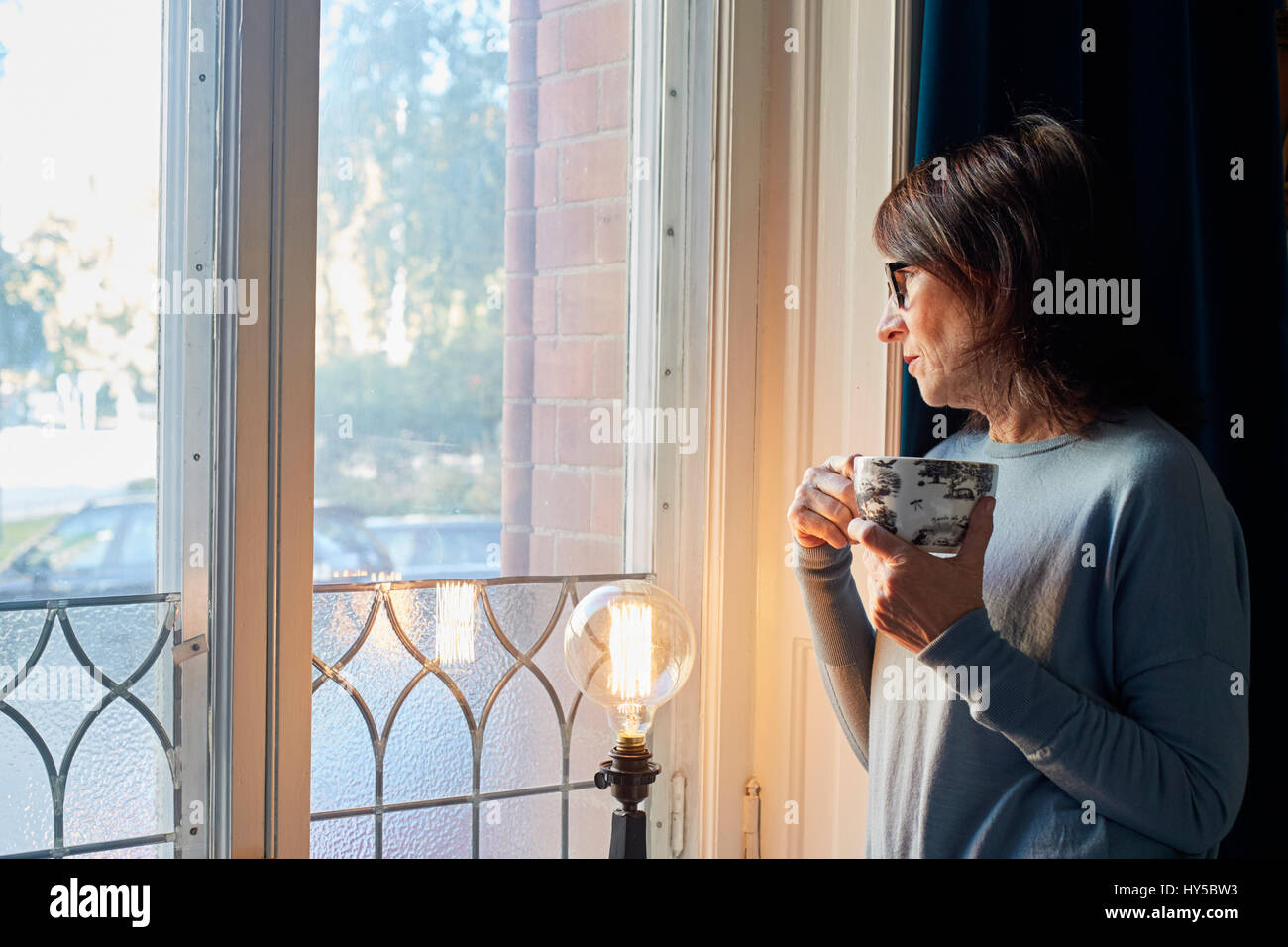 La Suède, la femme à la fenêtre, par l'intermédiaire de holding Coffee cup Banque D'Images