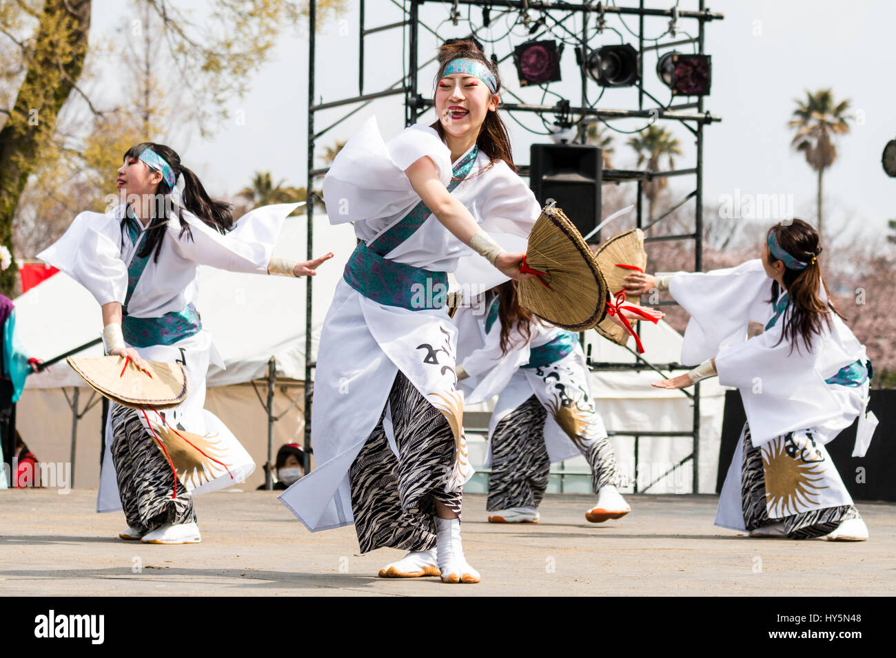 Le Japon, Kumamoto, Hinokuni danse Yosakoi Festival. Les danseurs en blanc femme yukata et blue head-band, l'agriculteur détenant des chapeaux de paille, de danser sur scène. Banque D'Images