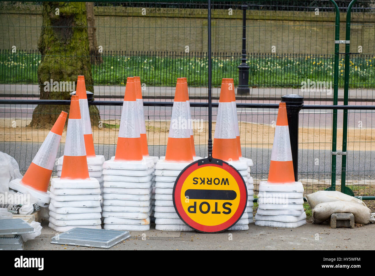 Cônes de circulation superposés et un signe d'arrêt des travaux sur le côté d'un enclos road Banque D'Images