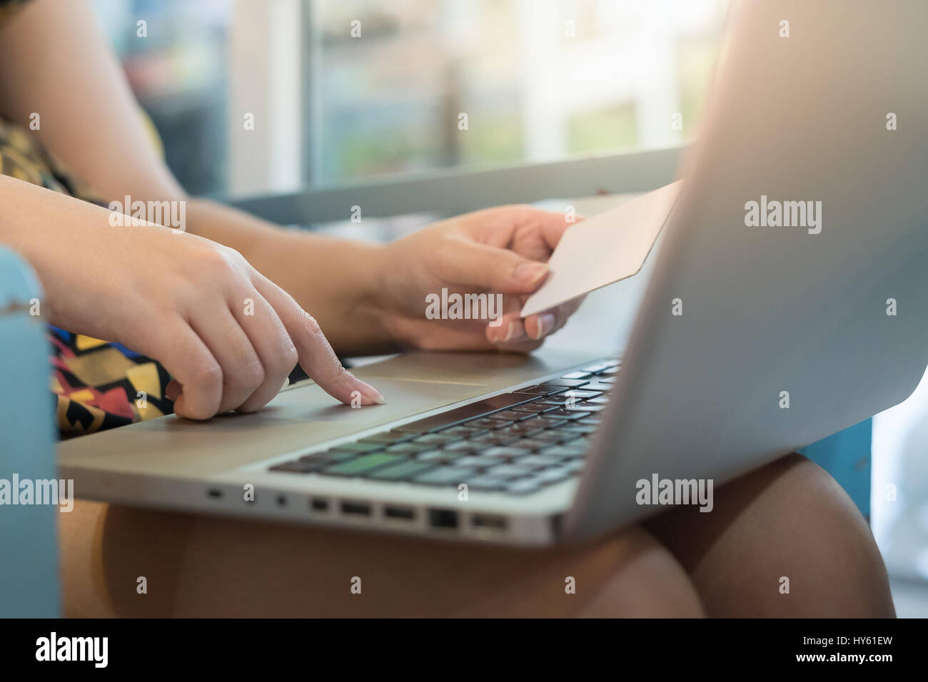 Femme l'index appuyer sur le bouton sur l'ordinateur portable pendant que l'autre main tenant une carte de crédit pour le paiement d'achats électroniques. Entreprise d'E-commerce à la maison c Banque D'Images