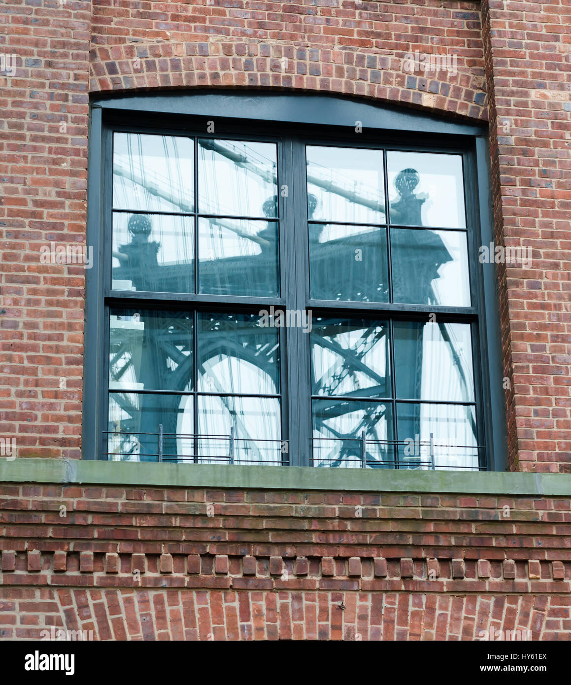 Reflet de Manhattan Bridge capturés dans un bâtiment en brique fenêtre dans Dumbo, Brooklyn, New York. Banque D'Images