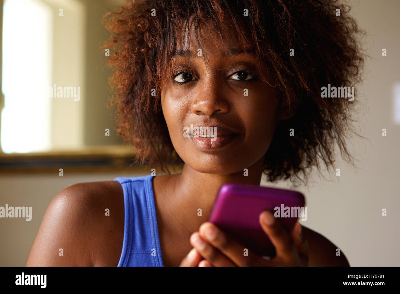 Close up portrait of a young african american woman with cell phone Banque D'Images