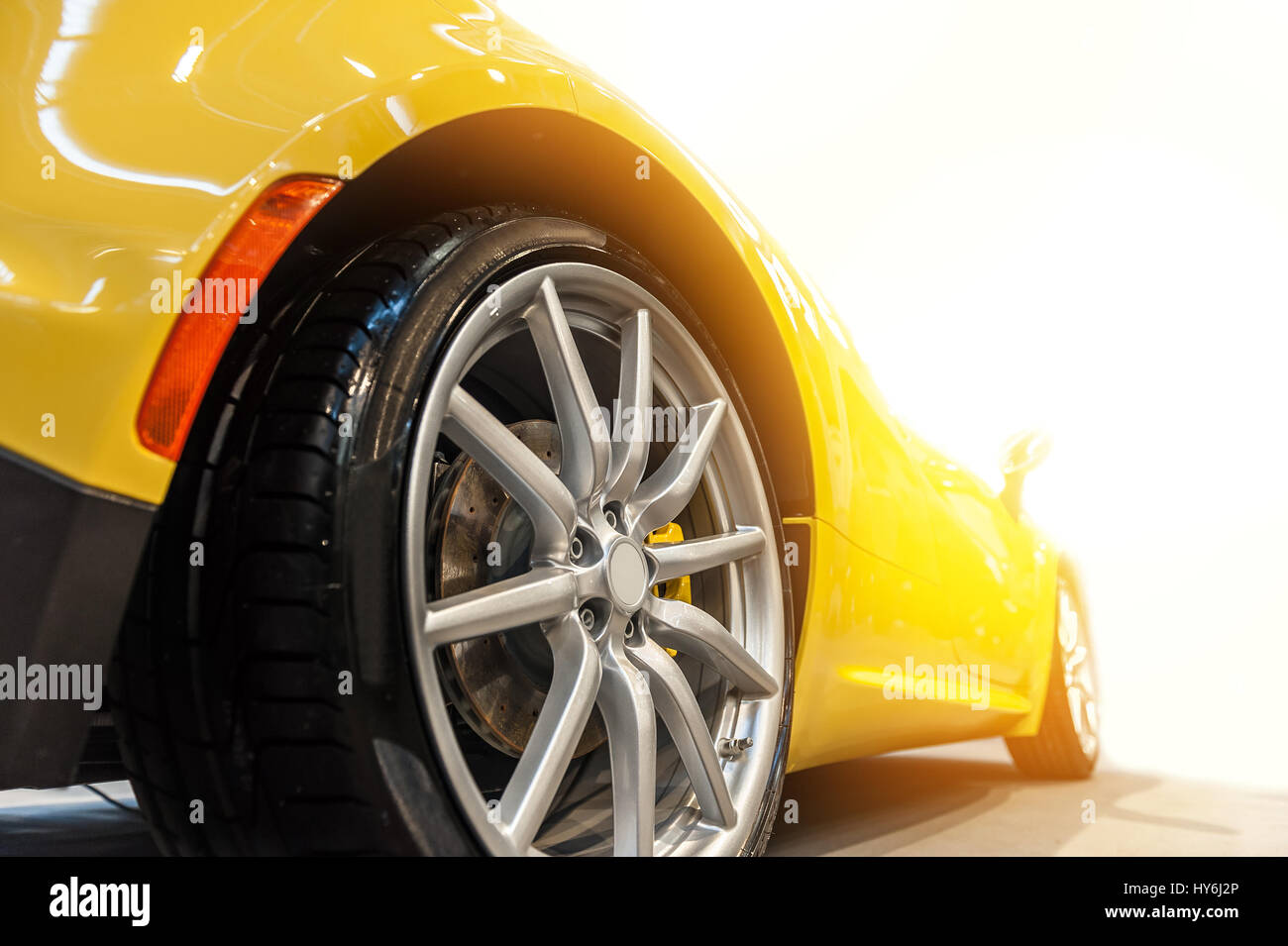 Arrière d'une voiture sport jaune générique isolé dans la lumière du soleil Banque D'Images