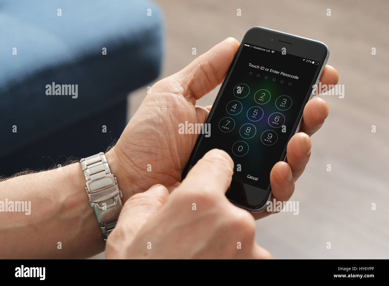 Kiev, Ukraine - Mars 06, 2016 : Un homme main tenant l'Apple iPhone 6 et entrez le code d'accès. Le téléphone cellulaire est produit par Apple Computer, Inc. Banque D'Images