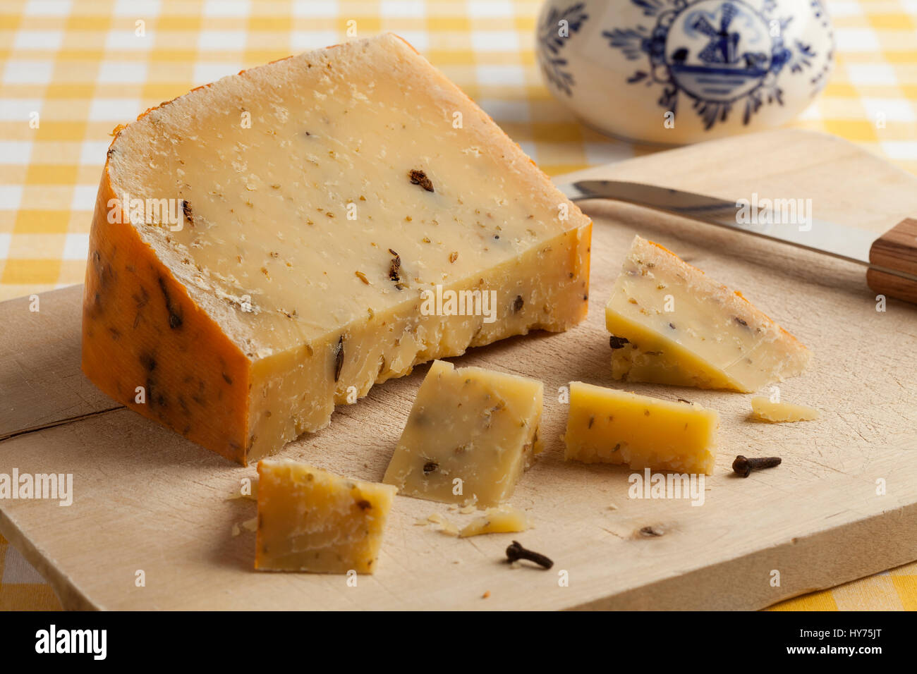 Morceau de fromage hollandais âgés de clous de girofle sur un cuttingboard pour dessert Banque D'Images