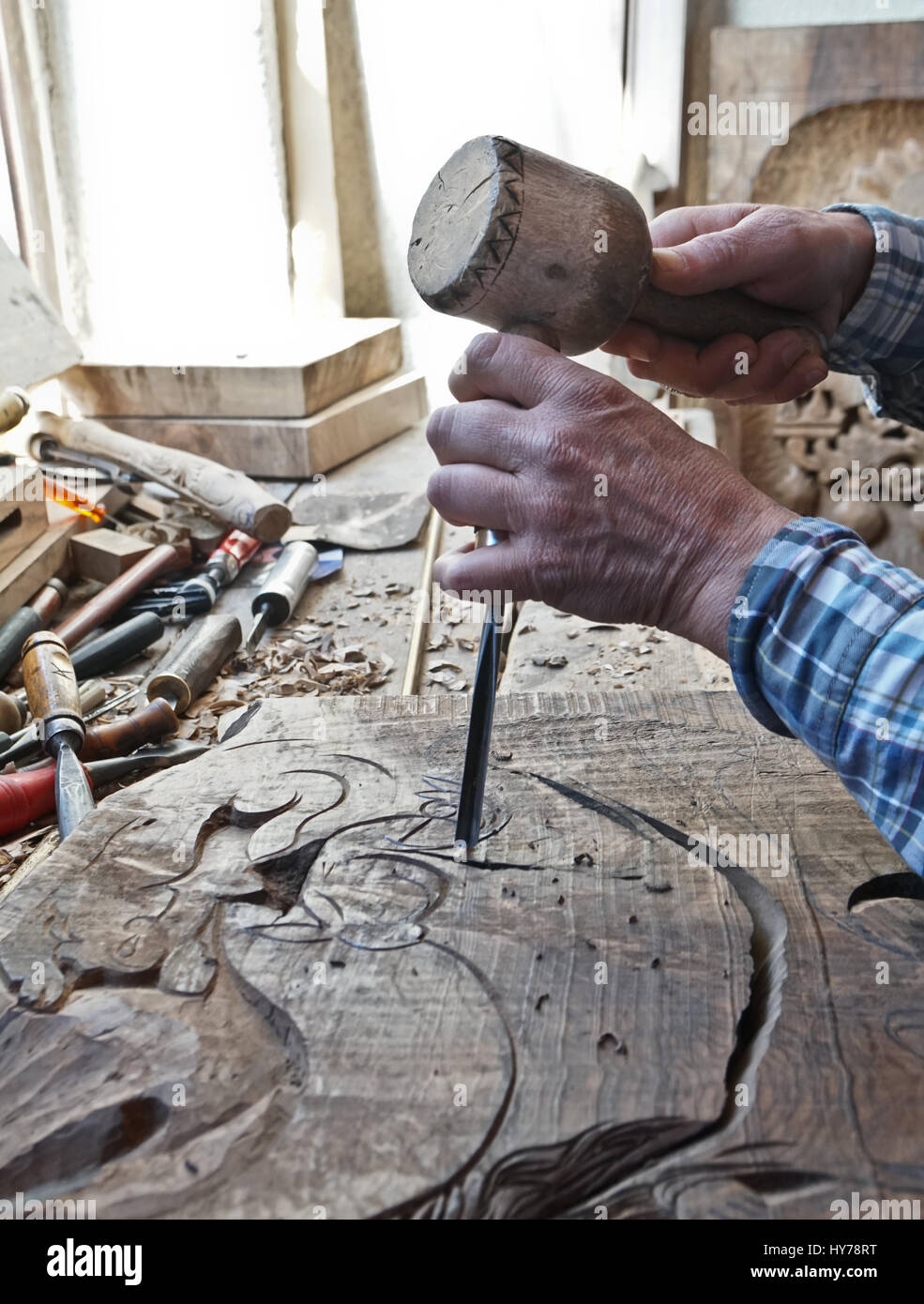 La sculpture sur bois. Carver avec un burin et un marteau. Un habile  artisan travaillant sur un panneau de bois décoration tailler Photo Stock -  Alamy