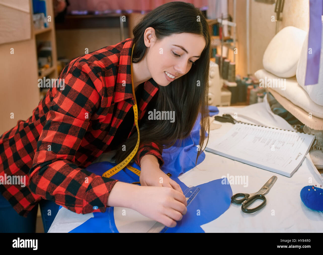 Jeune couturière faire motif sur tissu avec chalk tailleurs. Girl travailler avec un patron. Couture passe-temps comme une petite entreprise concept. Mea sur mesure Banque D'Images