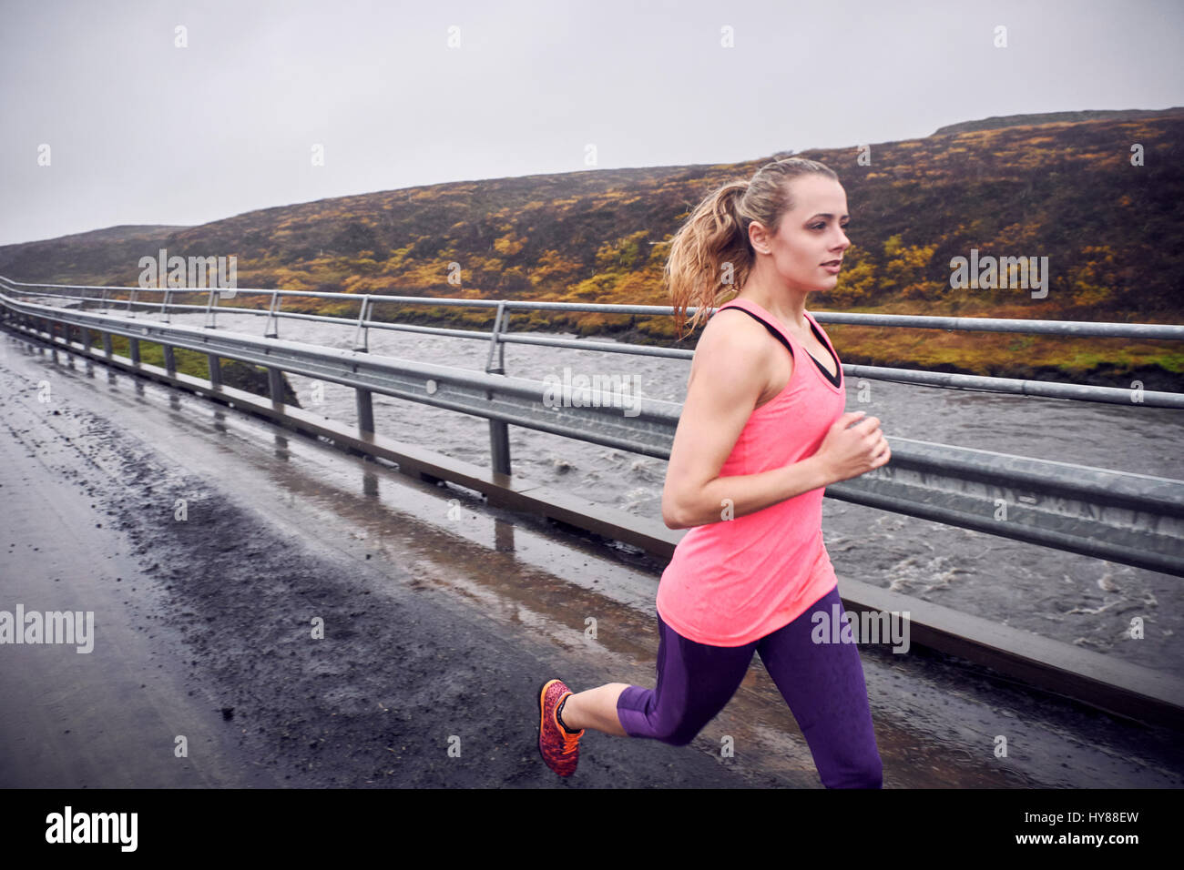 Les jeunes femmes s'exécutant sur un pont en pleine tempête l'Islande Banque D'Images