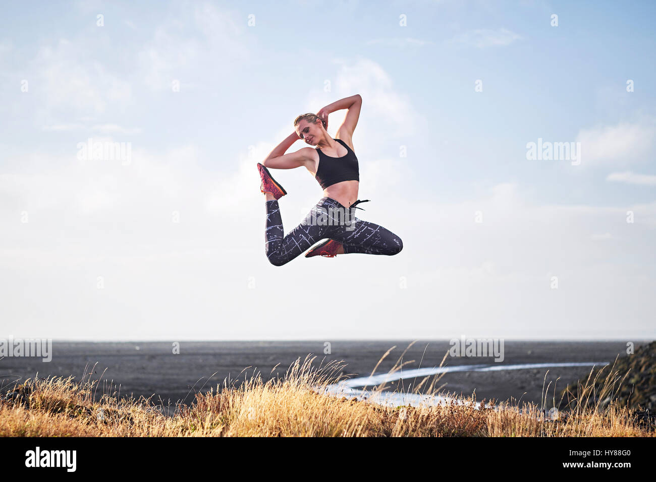 Les jeunes femmes sautant par une route de terre dans le sud de l'Islande Banque D'Images