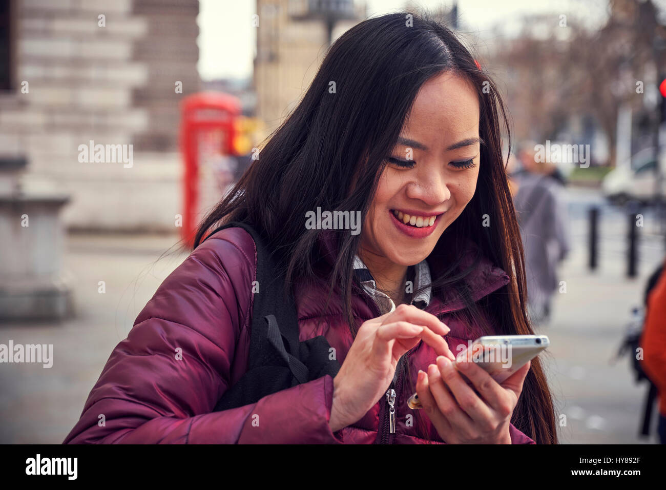 Une jeune japonaise à l'aide de son téléphone intelligent à Londres Banque D'Images