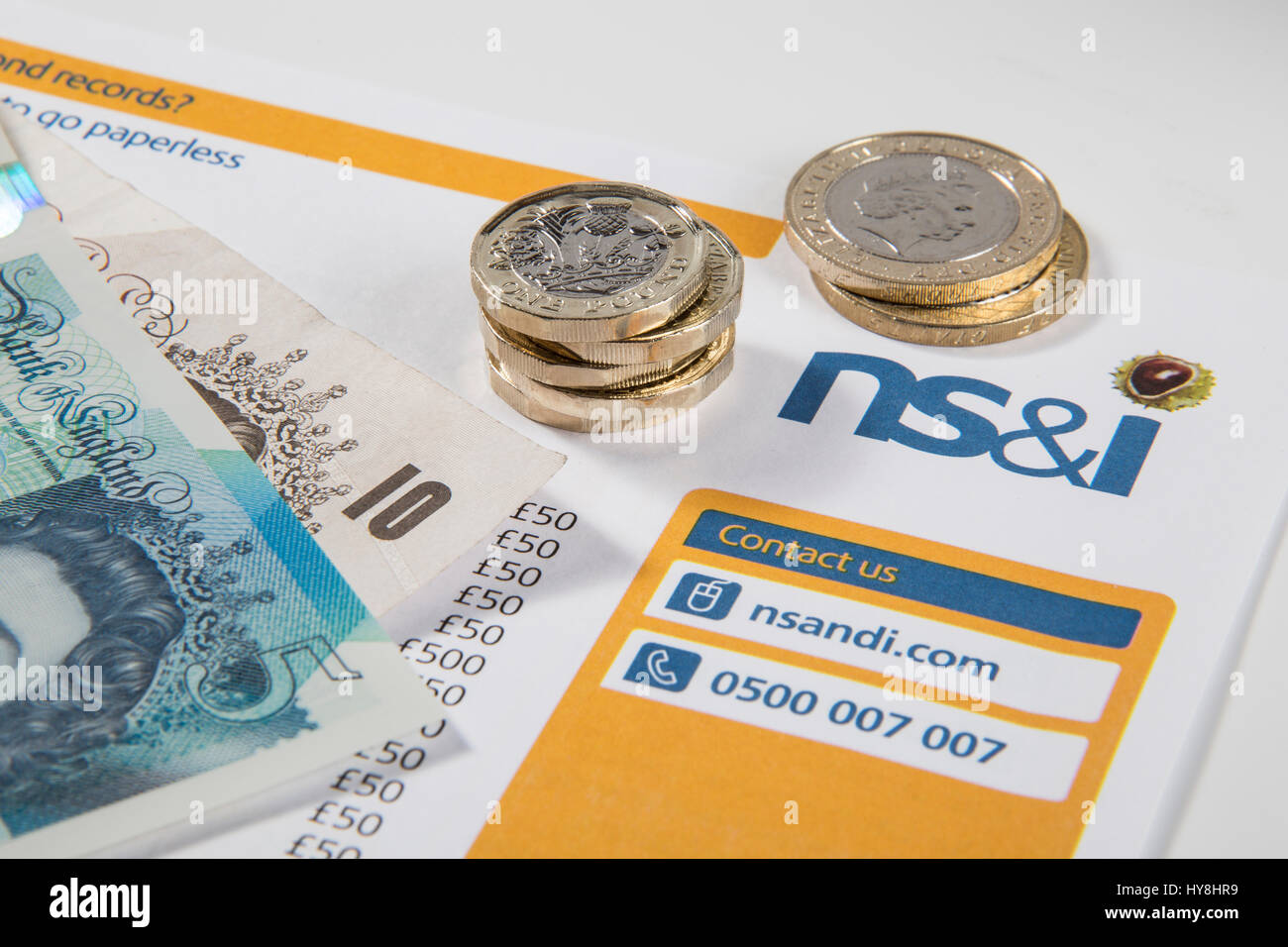 Nouvelles pièces livre £1, £2 et £5 pièces livre pound notes sur un prime NS&I document Banque D'Images
