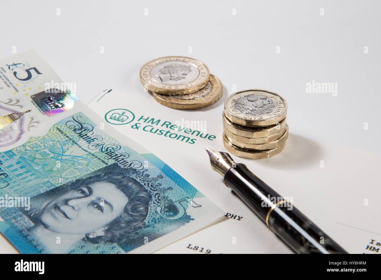 Nouvelles pièces livre £1, £2 et £5 pièces livre livre des notes sur un document des Douanes et revenus HM Banque D'Images