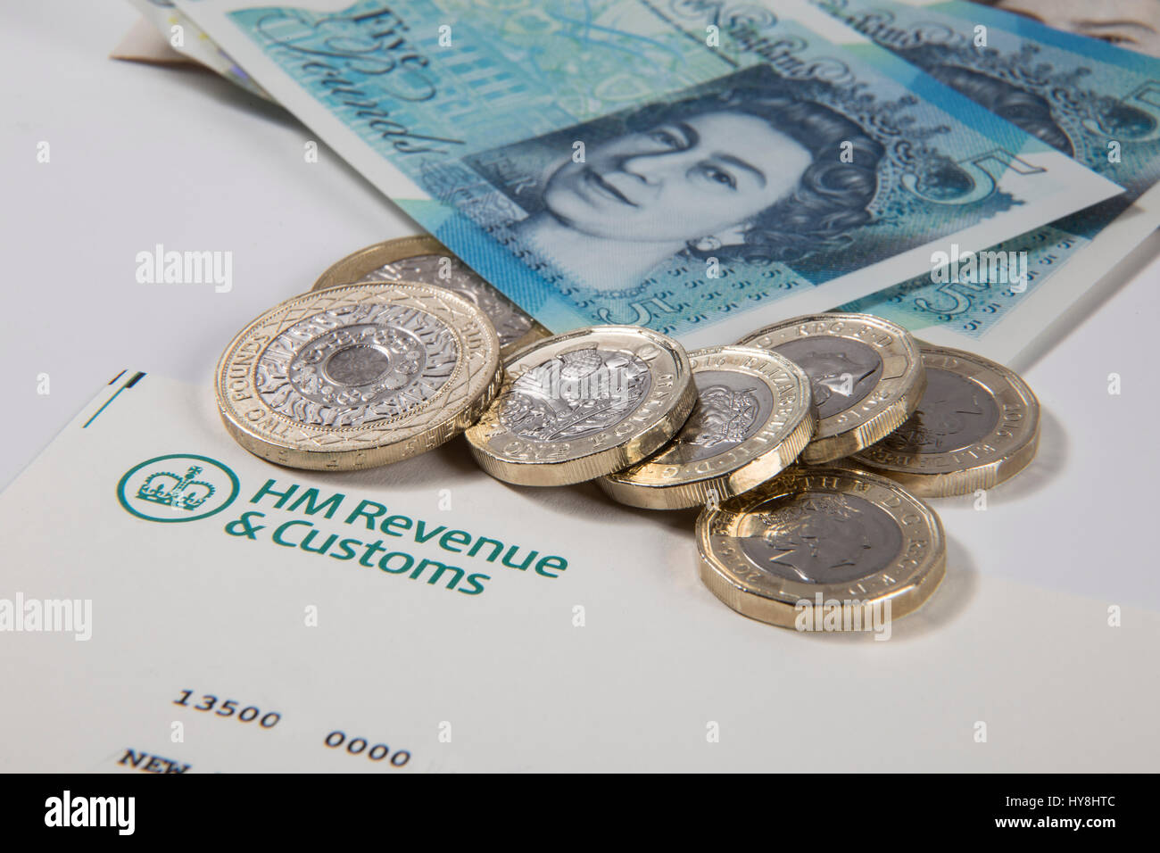 Nouvelles pièces livre £1, £2 et £5 pièces livre livre des notes sur un document des Douanes et revenus HM Banque D'Images