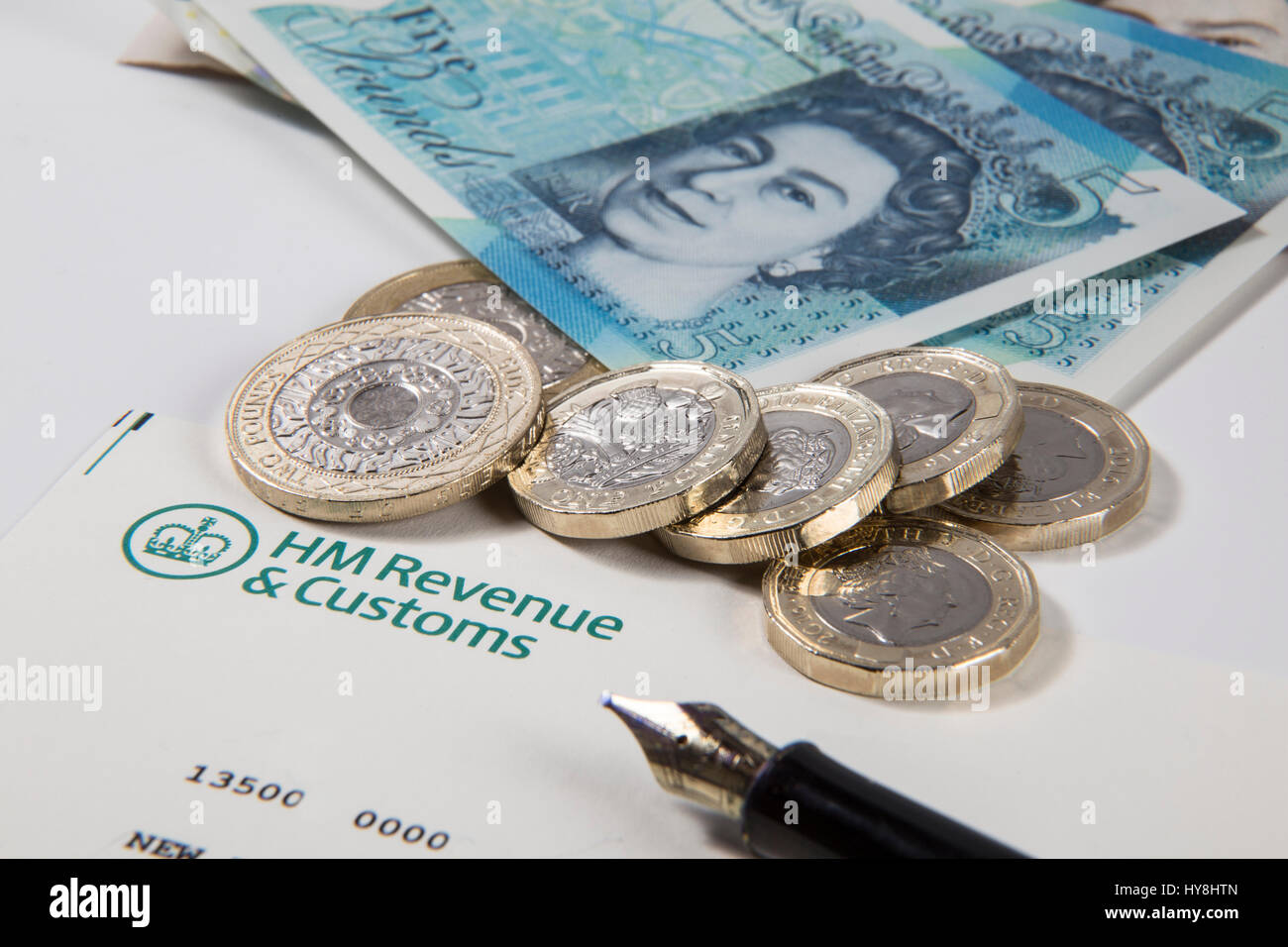 Nouvelles pièces livre £1, £2 et £5 pièces livre livre des notes sur un document des Douanes et revenus HM Banque D'Images