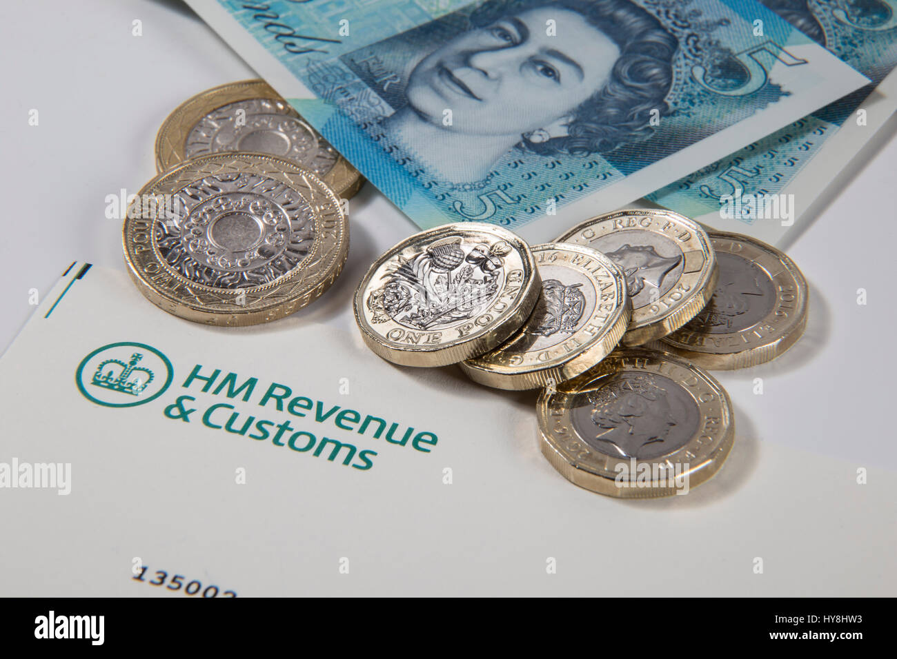 Nouvelles pièces livre £1, £2 et £5 pièces livre livre des notes sur un document des Douanes et revenus HM Banque D'Images