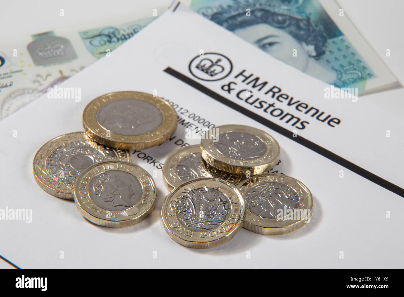 Nouvelles pièces livre £1, £2 et £5 pièces livre livre des notes sur un document des Douanes et revenus HM Banque D'Images