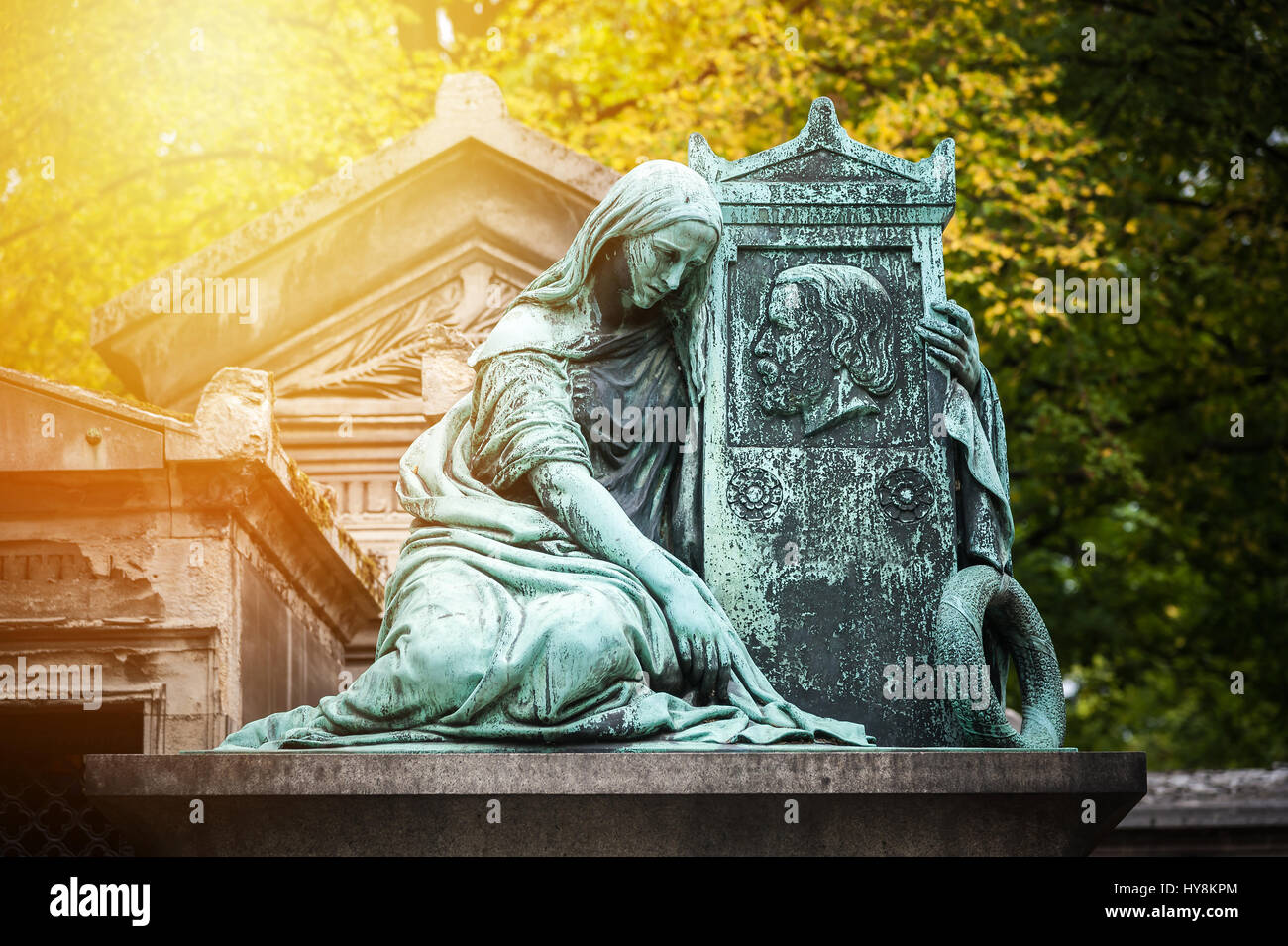 Statue dans un cimetière de Paris au coucher du soleil Banque D'Images