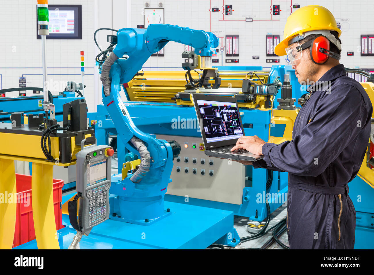 Ordinateur portable à l'aide de l'ingénieur de contrôle pour machine-outil main robotisée automatique à l'usine de fabrication industrielle Banque D'Images