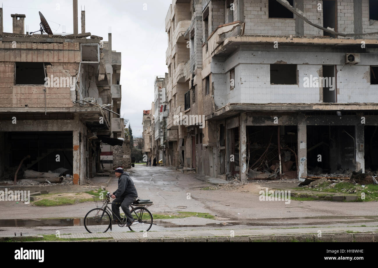 Bicycler in distressed district dans Baba Amr à Homs, en Syrie au début de 2017 Banque D'Images