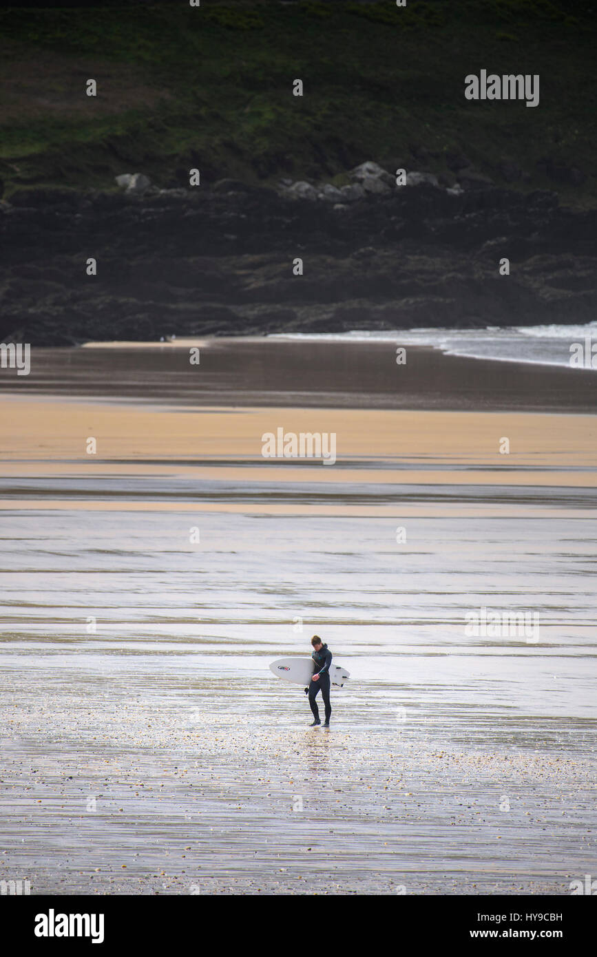 Surfer Walking Home Terminé fatigué transportant la plage de surf de la Côte sauvage de bord de rive Cornwall Fistral côtières Banque D'Images