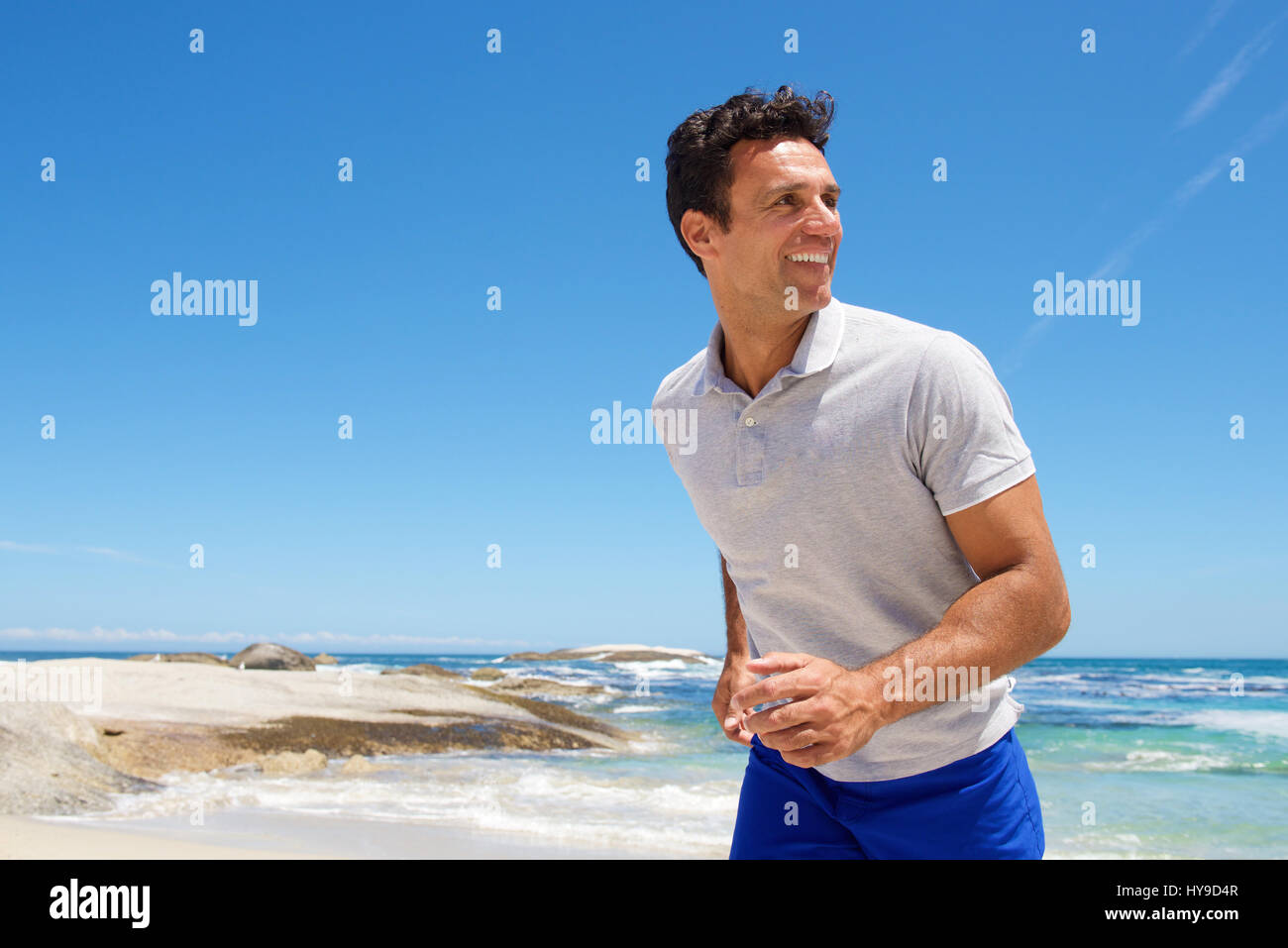 Portrait of a happy middle aged man walking on the beach Banque D'Images