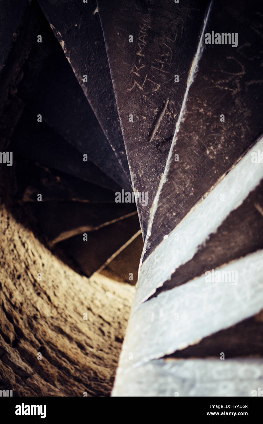 Une image couleur d'un ancien escalier en pierre étrange d'en bas avec une lumière au bout du tunnel. Il y a voulu graffiti sur les marches. Banque D'Images