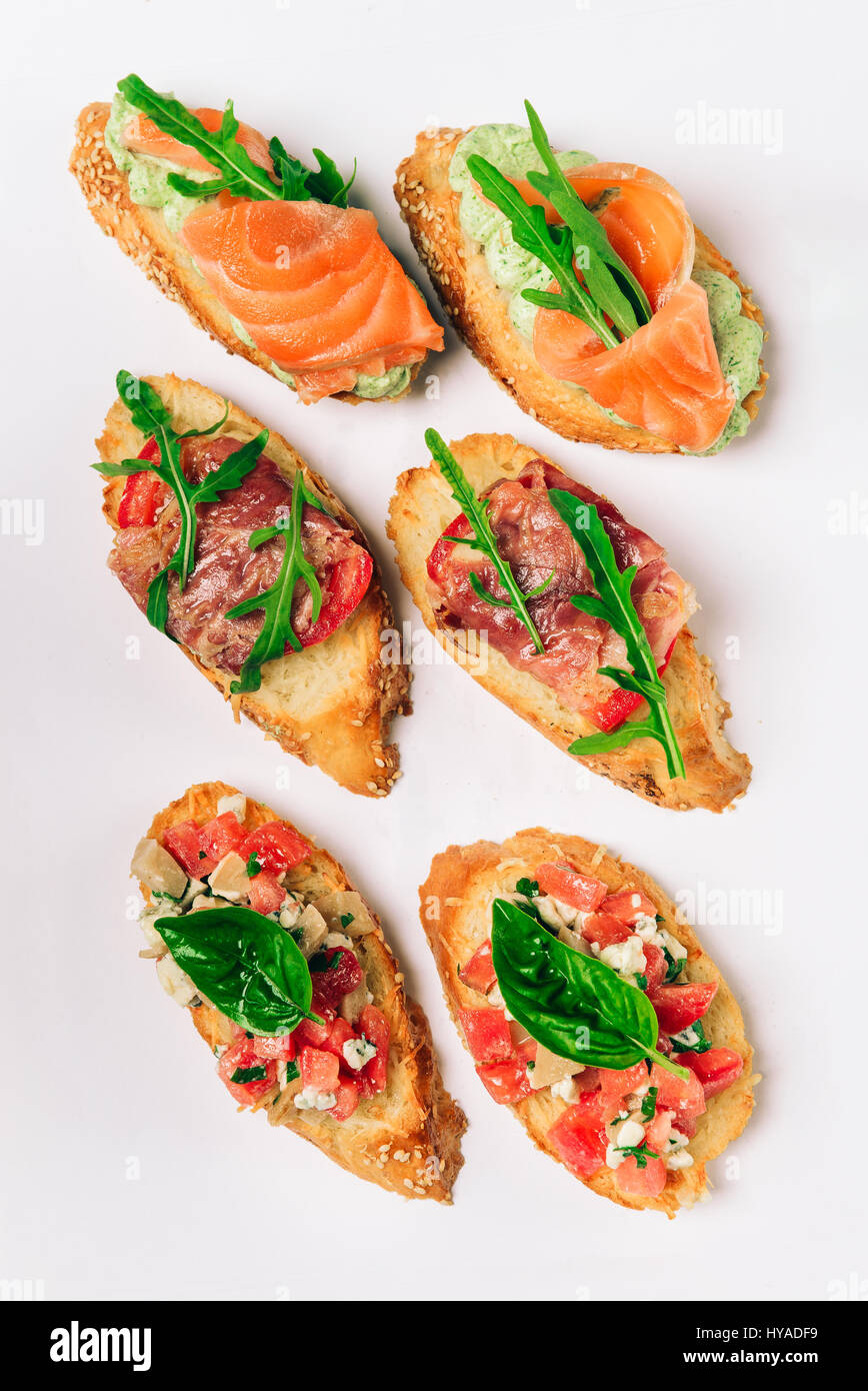 Six bruschettes avec verts, fromage, viande et poisson Banque D'Images