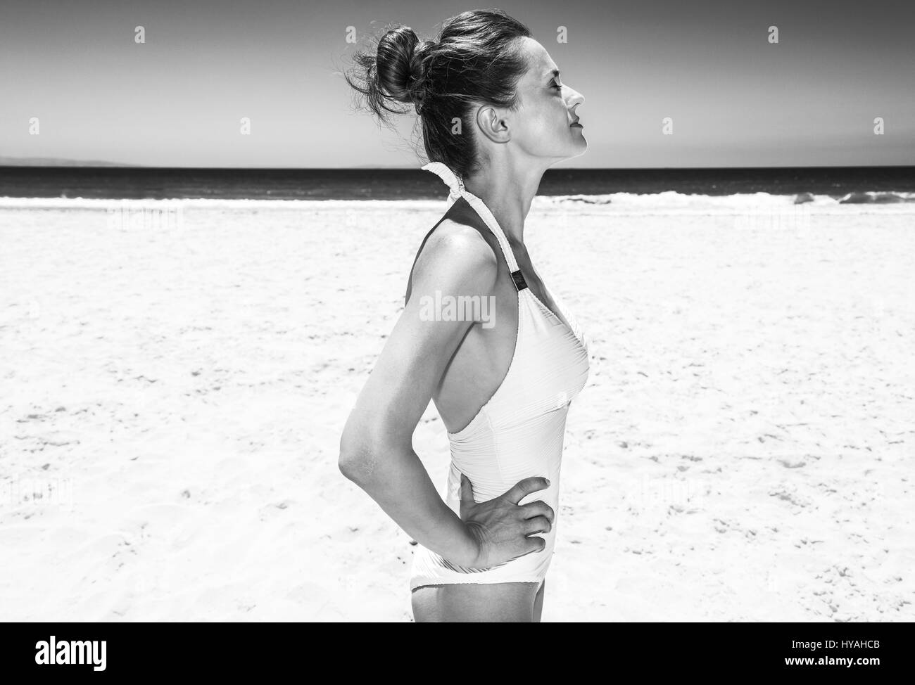 La position de sable blanc mer bleu paradis. Femme en maillot blanc détendue à sandy beach sur une journée ensoleillée Banque D'Images