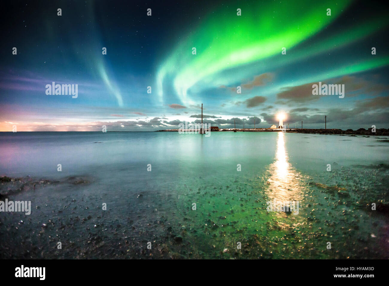 KEFLAVIK, ISLANDE : une aurore est reflet dans l'eau tranquille. Réflexions AURORA pack deux fois le poinçon de la nature la plus spectaculaire de lumières. Danser dans le ciel de couleurs kaléidoscopiques de l'Icelandic aurora, aussi appelée la northern lights, peut être vue reflétée dans l'eau ci-dessous. Comme une illusion optique en quelques photos il est difficile de dire où les lumières fin et les réflexions commencent. Oli photographe Haukur (33) a été la capture les lumières sur l'appareil-photo prise à Keflavik, Islande et expliqué sa fascination pour l'émerveillement. Banque D'Images