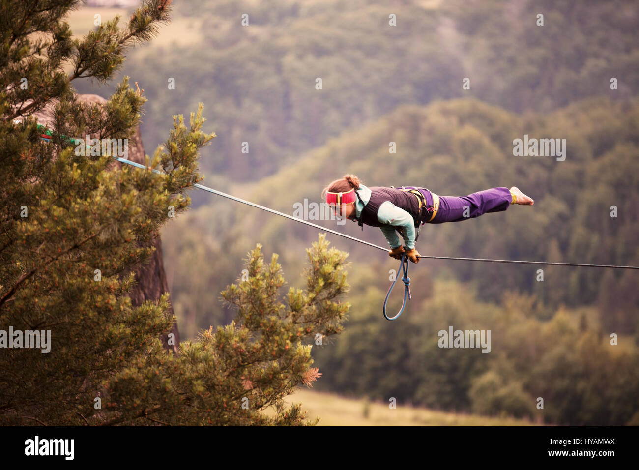 OSTROV, RÉPUBLIQUE TCHÈQUE : une femelle slackliner montre en haute-fil. De s'habiller en costume d'embaucher des fils ce yoga tous-girl gang voir le côté plus léger à l'extrême, sport qu'ils appellent slackline. Habillée comme une jeune fille des années 40, 'Pays' - Faith Dickey (24) peut être vu remplissant un des free-solo à pied sans une ligne de sécurité, à 100 pieds du sol. D'autres photos montrent plus sassy femme slackliners effectuant en haute-ligne dans des positions extrêmes ainsi que larking autour en costume. Un petit angle de caméra près d'une montre jusqu'à la jupe shot. La collection de photos a été prise par phot Banque D'Images