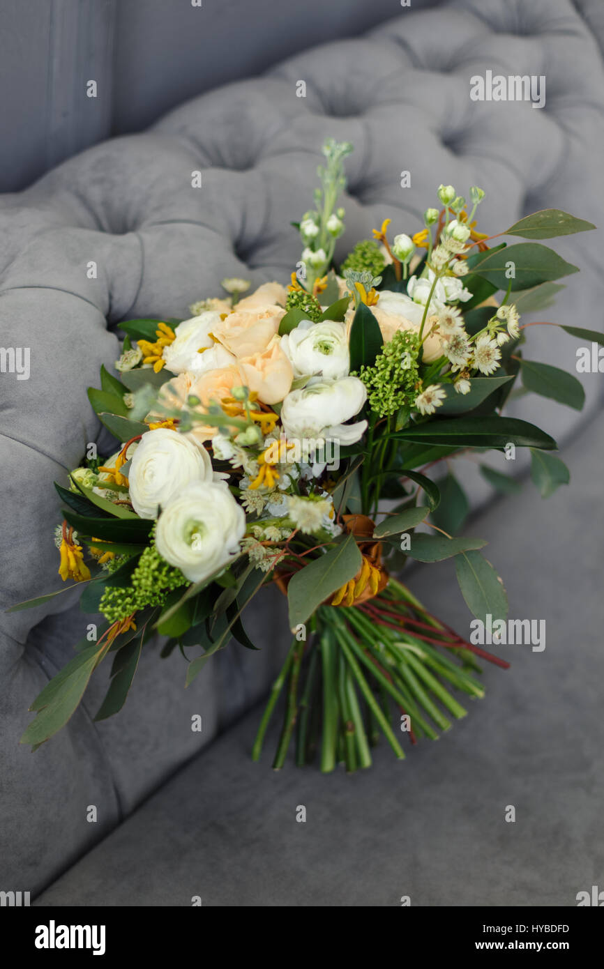 Mariage bouquet de roses crème et blanc de pivoines dans un style rustique sur un fond gris canapé Banque D'Images