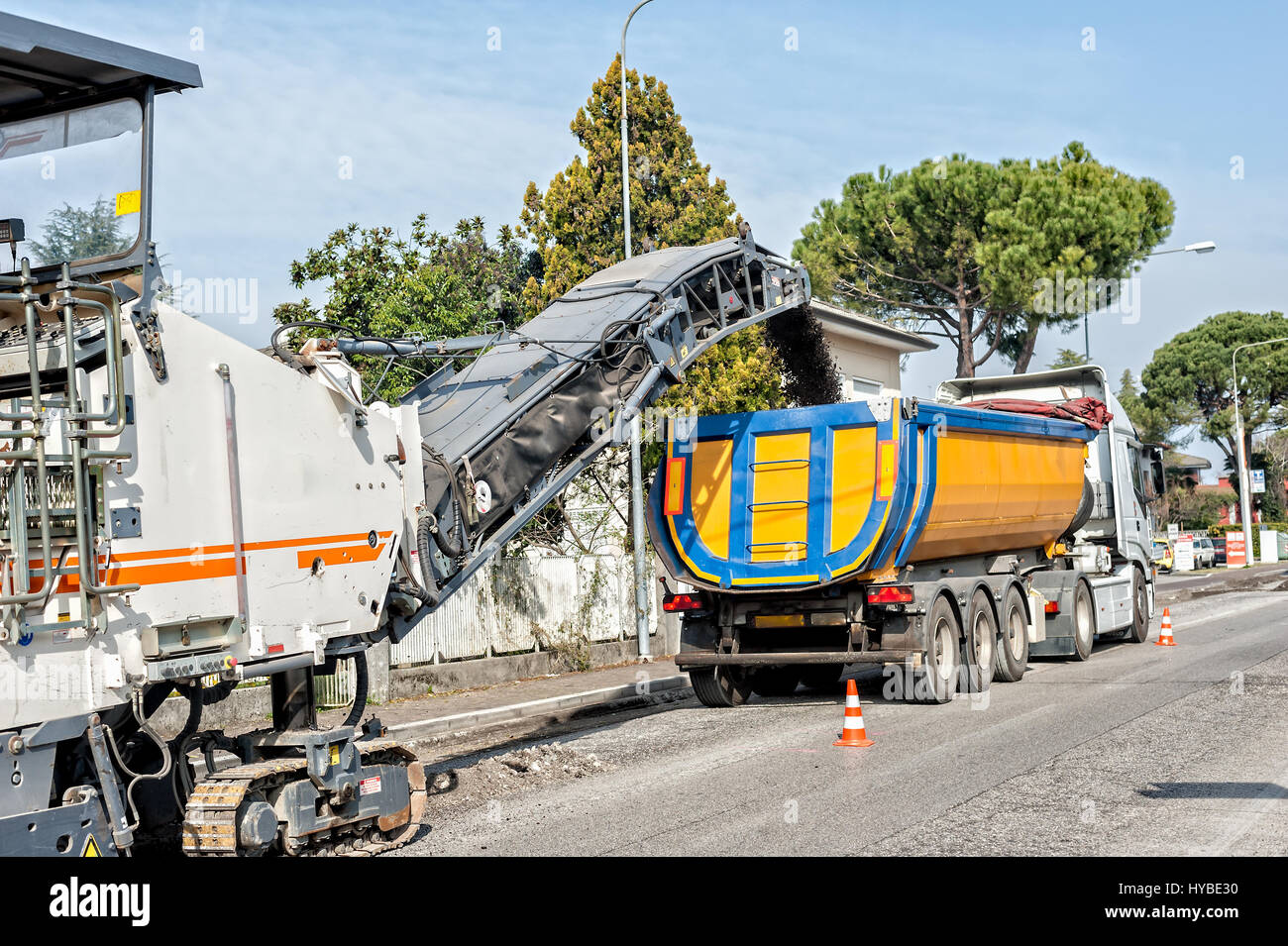 Les travaux routiers avec une route asphaltée, la dépose de l'ancienne machine de fraisage à partir d'un revêtement de surface de la rue. Charge les débris sur un camion Banque D'Images