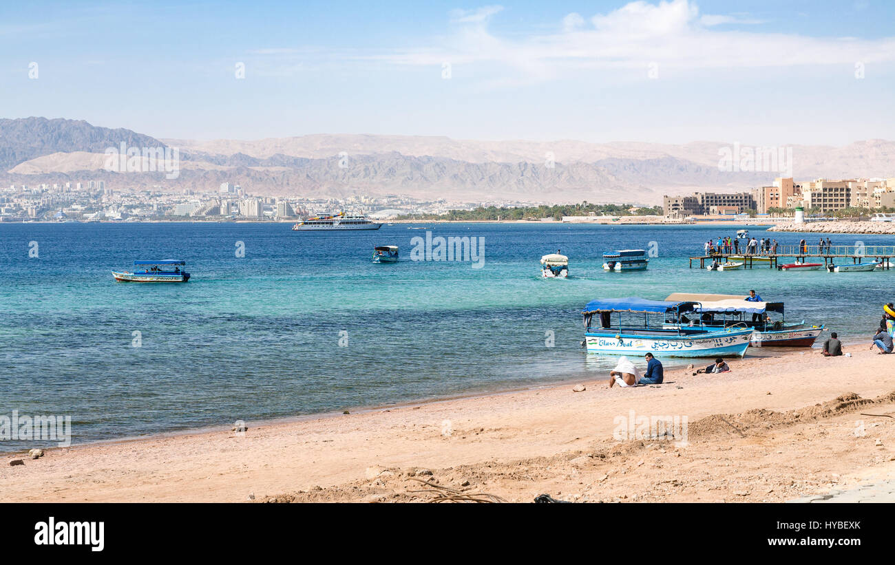 AQABA, JORDANIE - février 23, 2012 : la plage de la ville d'Aqaba et d'Eilat voir la ville en arrière-plan dans la journée d'hiver. La Jordanie pays n'a qu'une sortie en mer à bord Banque D'Images