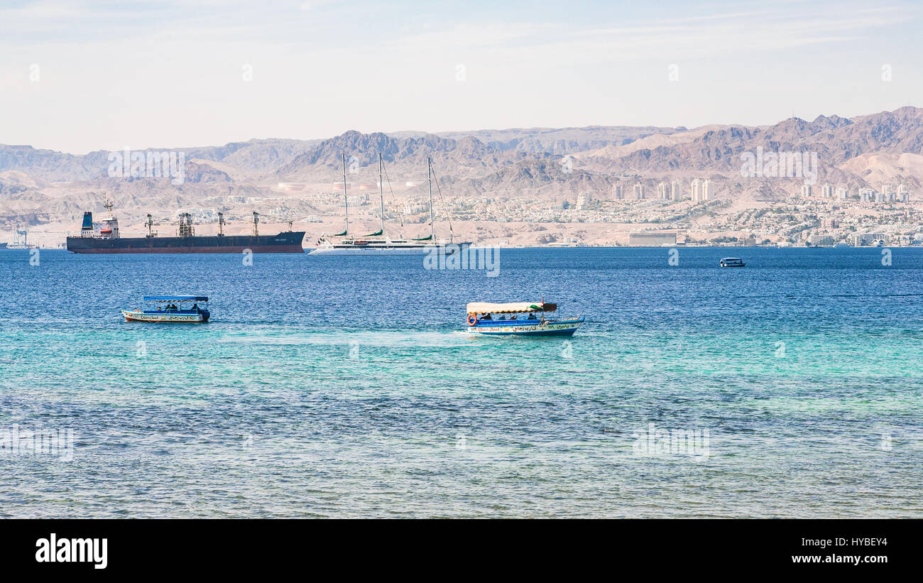 AQABA, JORDANIE - février 23, 2012 : bateaux dans Golfe d'Aqaba et d'Eilat voir la ville en arrière-plan en hiver. La Jordanie pays n'a qu'une sortie à la mer Banque D'Images