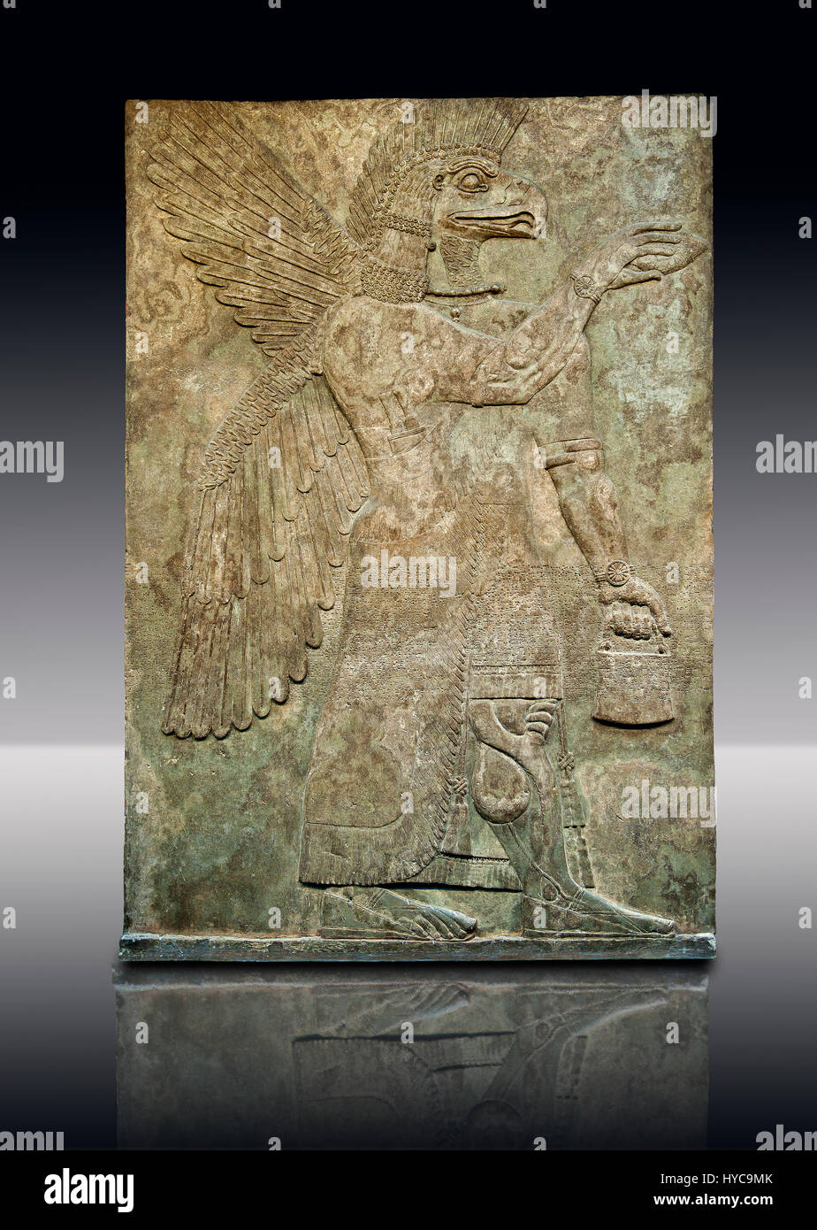 Sculpture bas-relief assyrien de bord d'un esprit protecteur avec une tête blanche de Nimrud, de l'Iraq. L'esprit est la tenue d'une fir cone et symbolique est sprink Banque D'Images