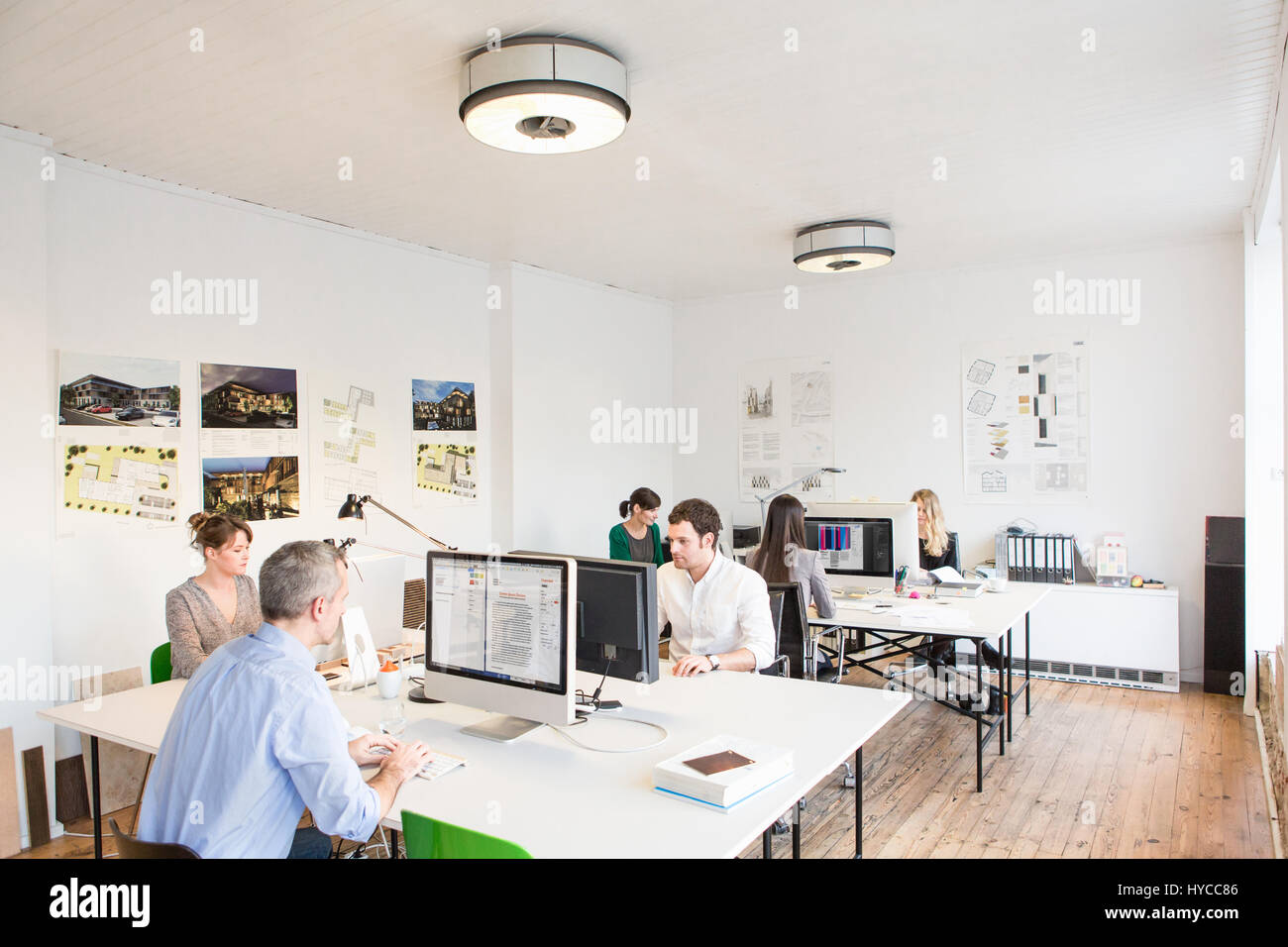 Collègues de bureau assis à un bureau à l'aide d'ordinateurs Banque D'Images