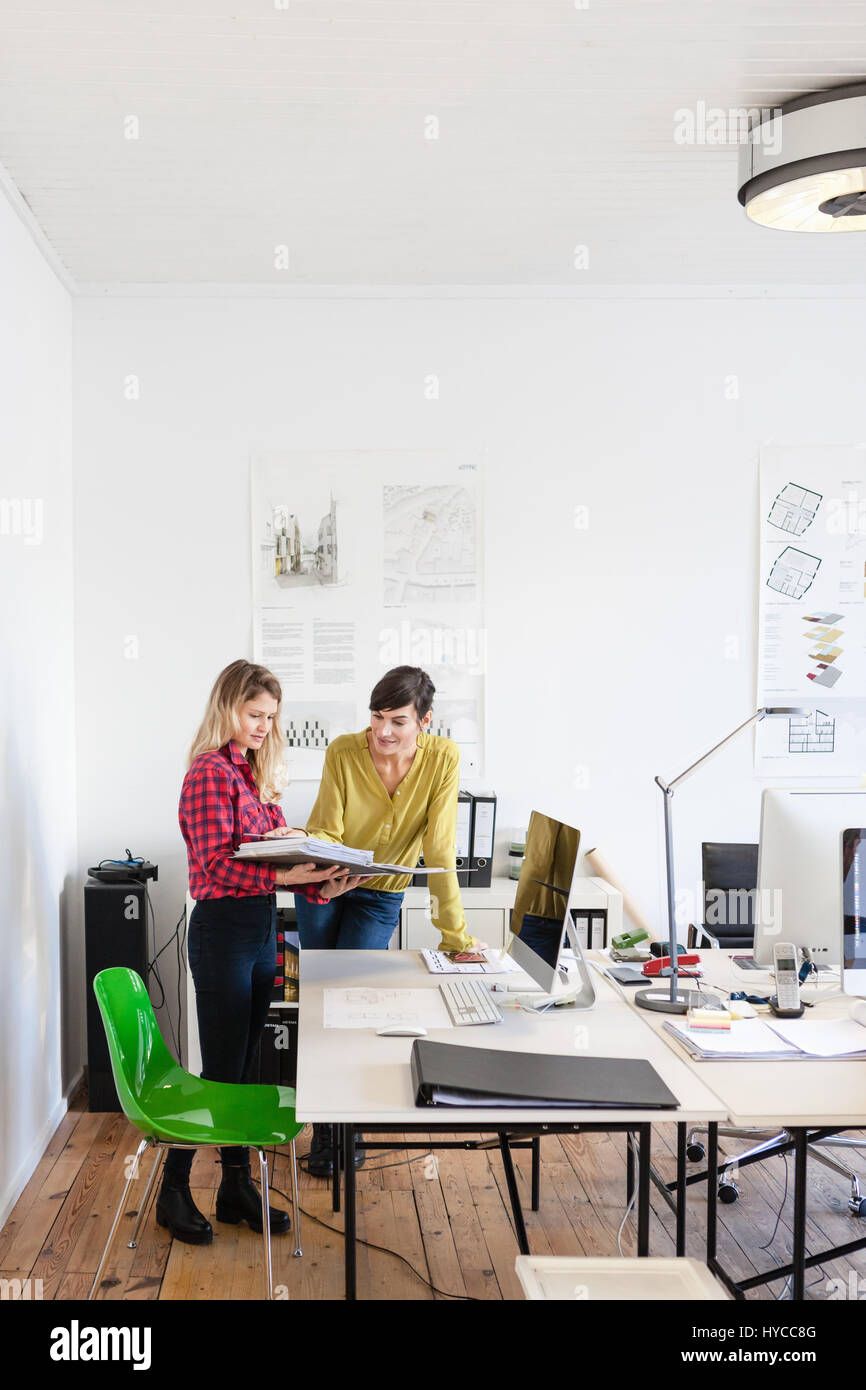 Collègues de bureau à la recherche de documents dans la relieuse Banque D'Images