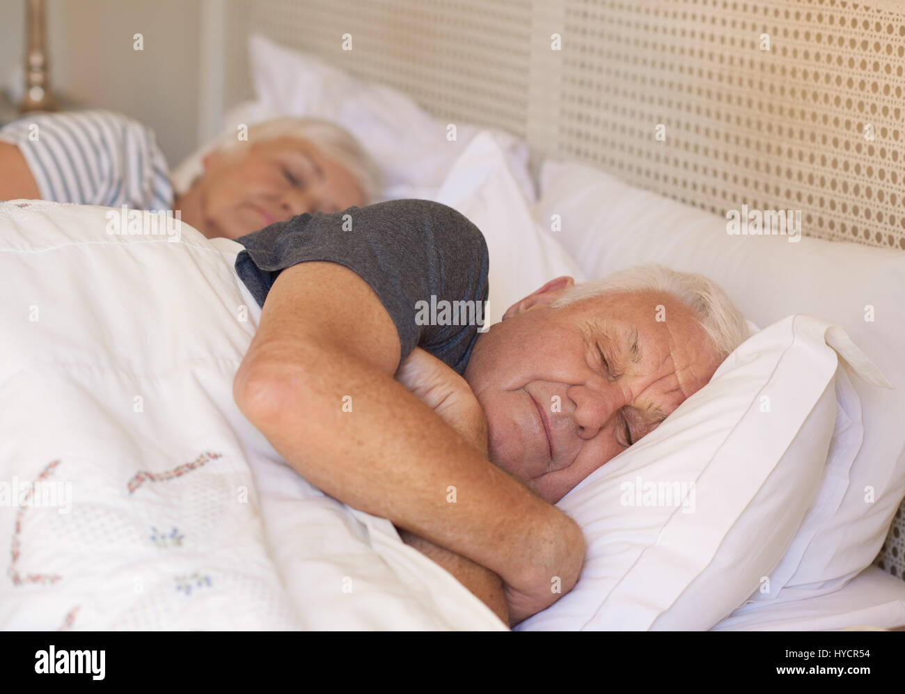 Man et sa femme endormie dans le lit à la maison Banque D'Images