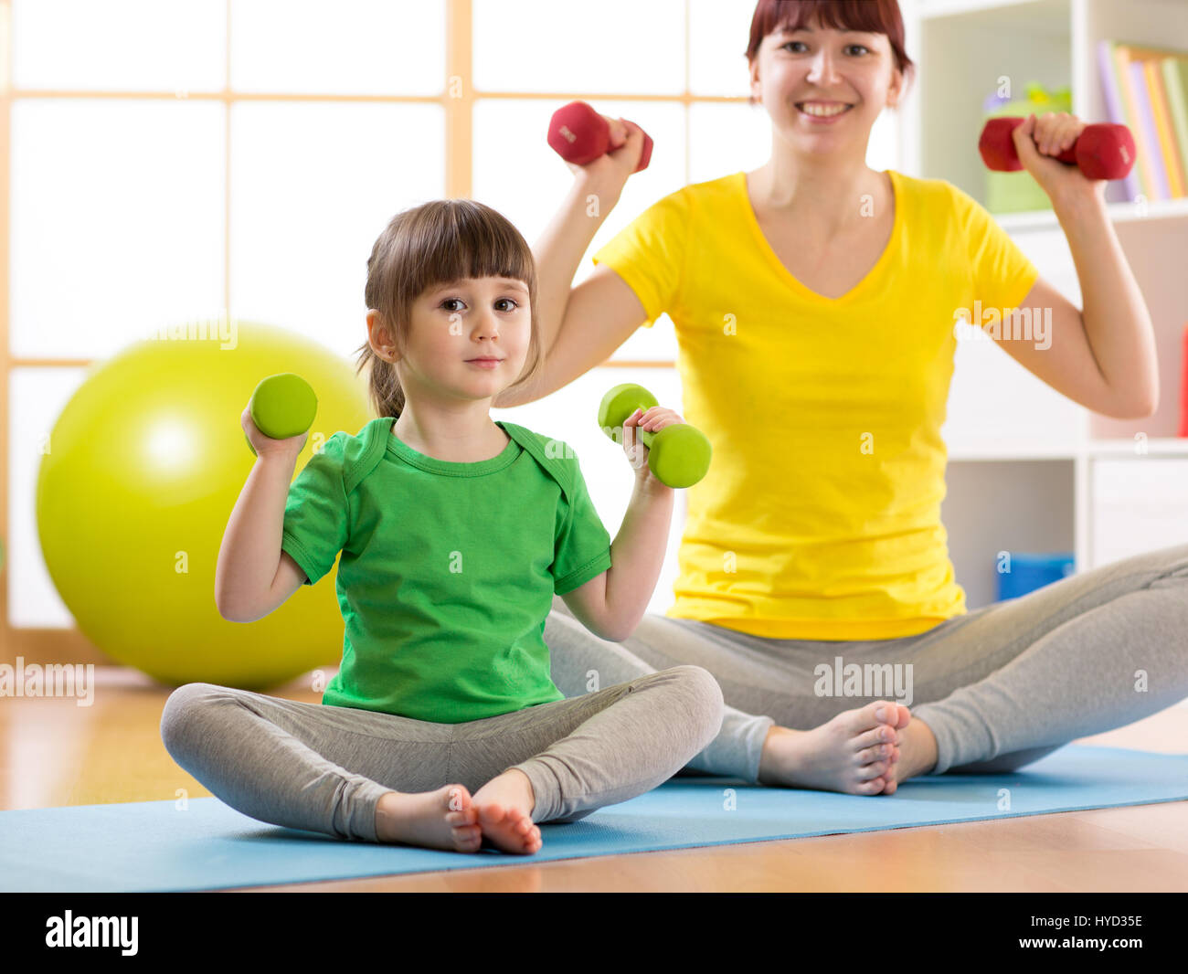 Femme et son enfant fille faisant des exercices de fitness avec haltères Banque D'Images