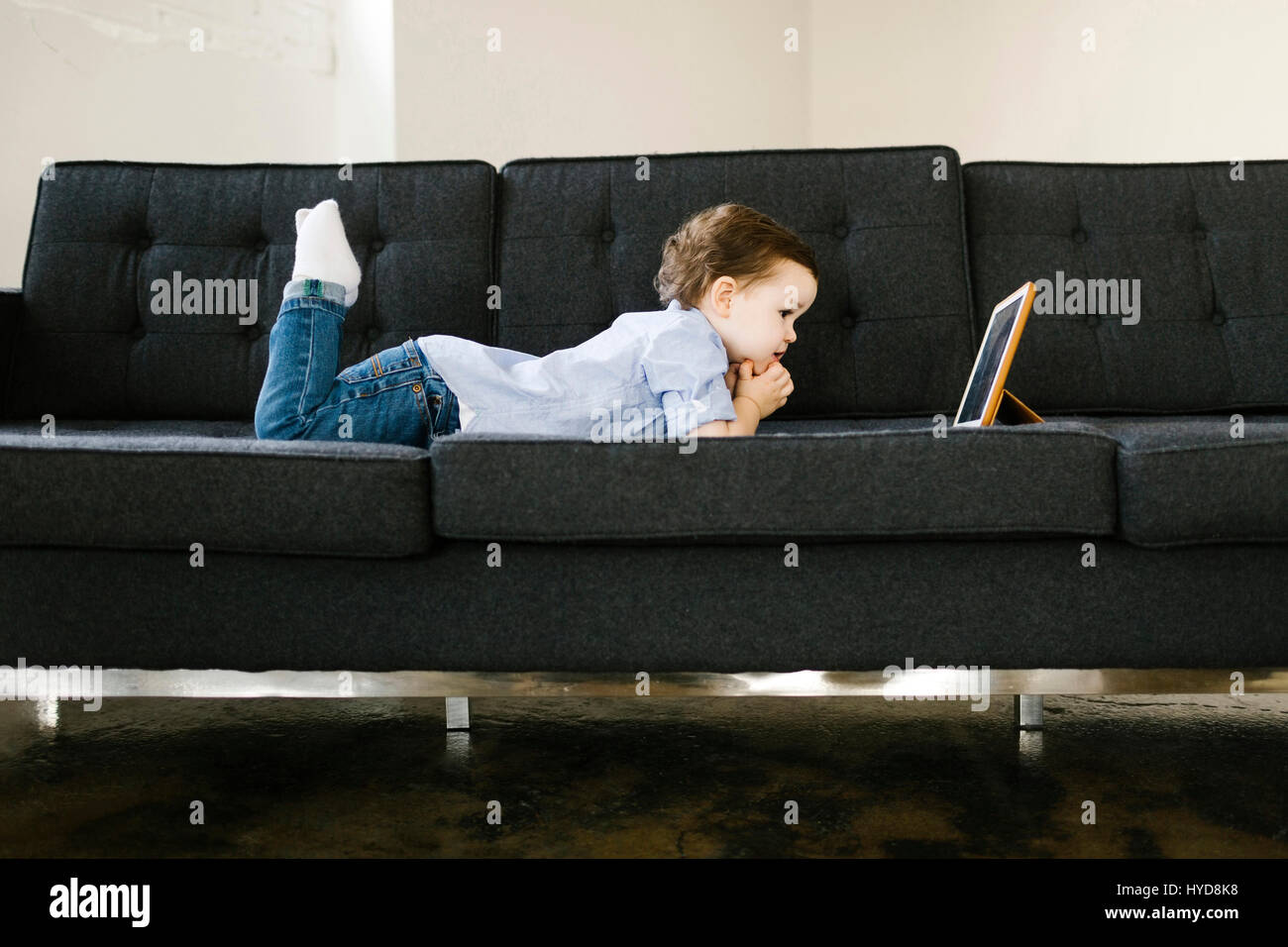 Jeune garçon (4-5) allongé sur un canapé Banque D'Images