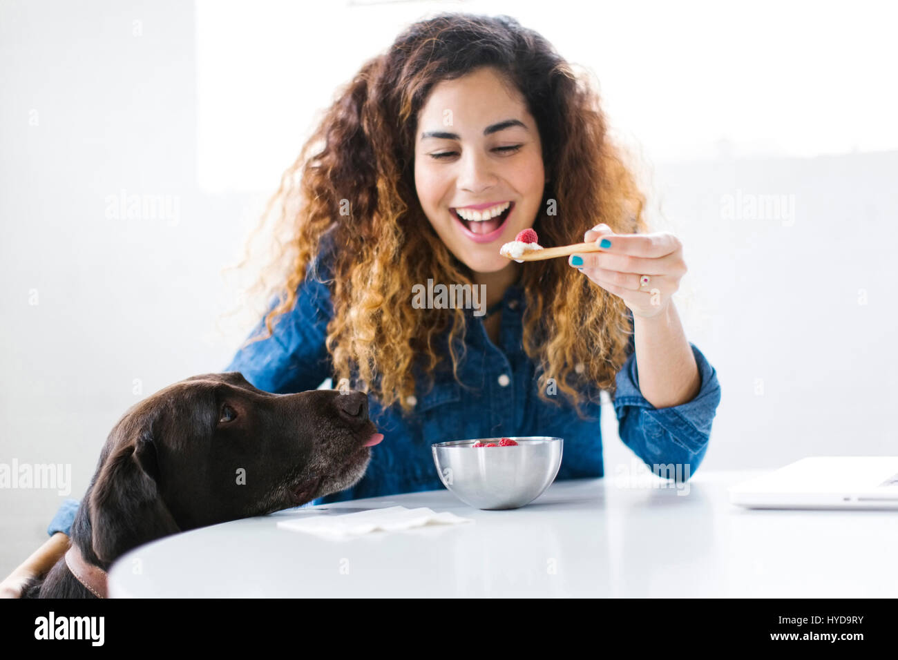 Femme avec chien manger snack Banque D'Images