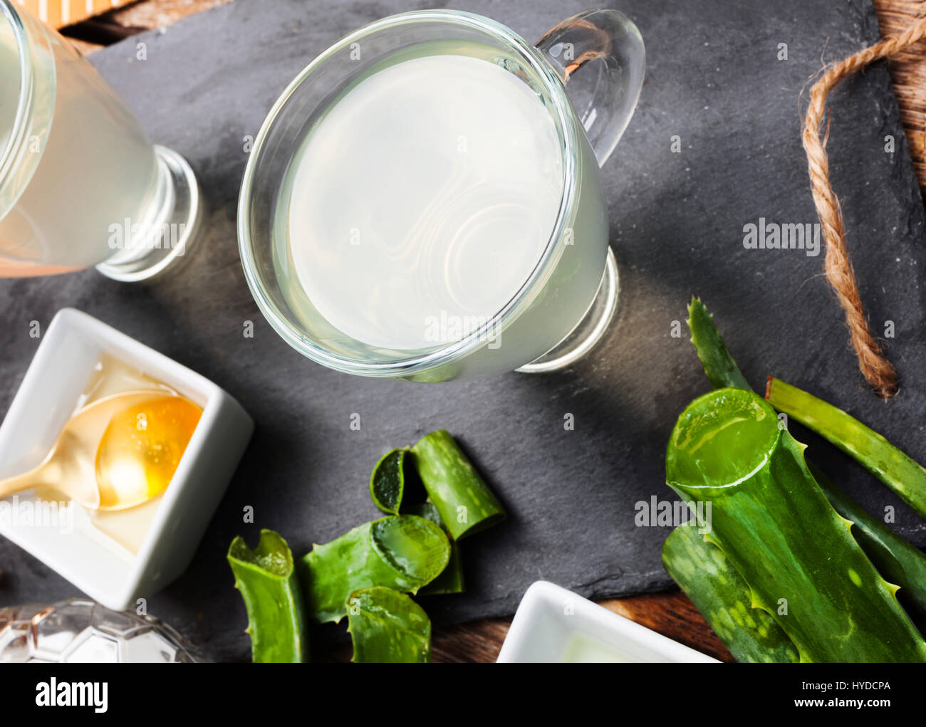 Boire de l'aloe vera et miel. Tasses en verre sur un plateau d'ardoise Banque D'Images