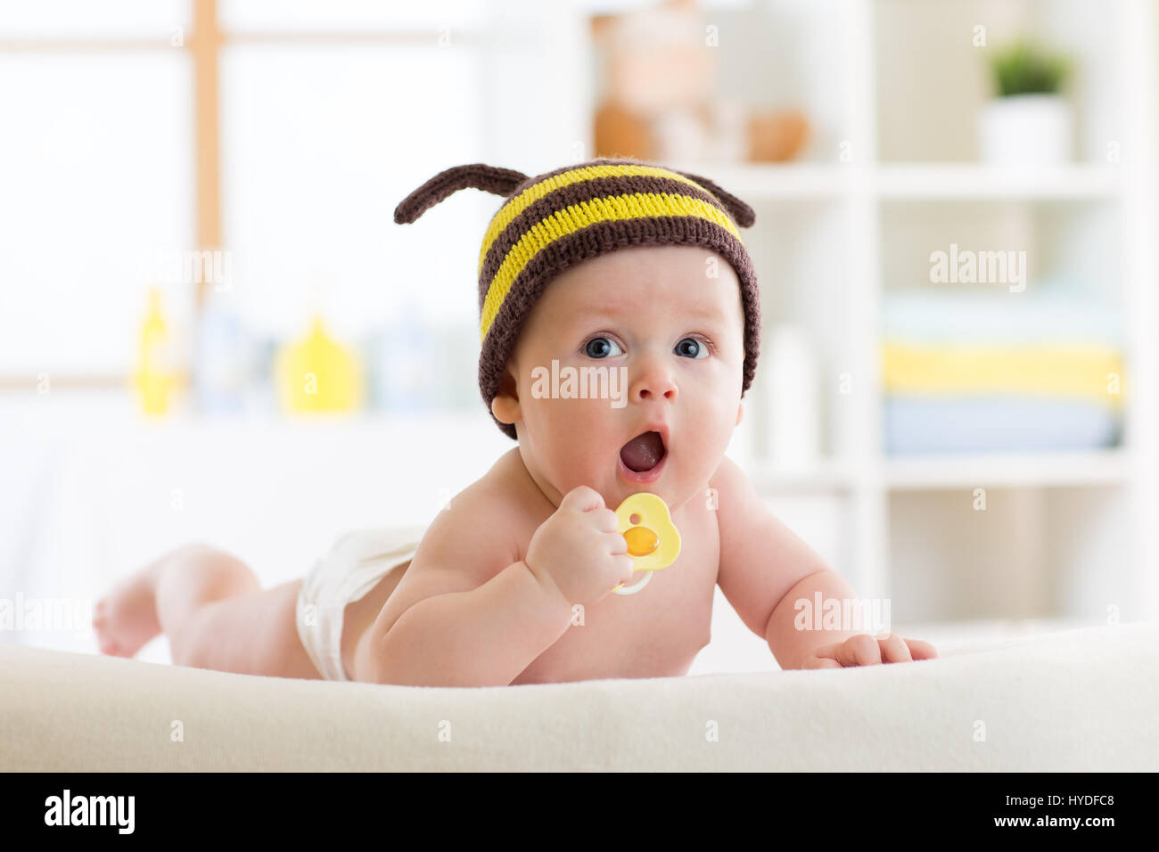 Mignon bébé avec tétine sur le lit à la maison Banque D'Images