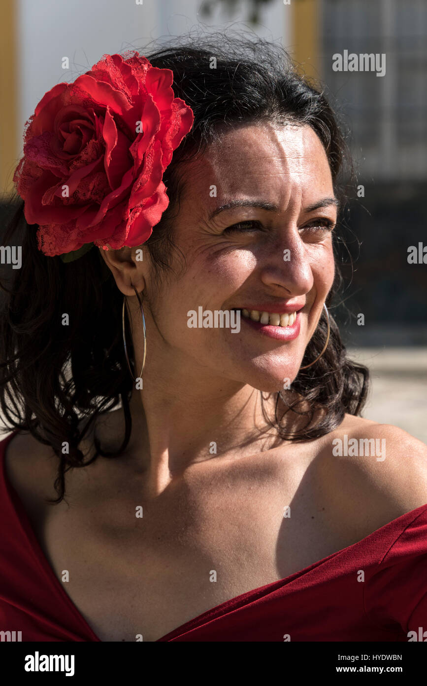 Une espagnole vêtue comme une danseuse de flamenco portant une rose rouge dans ses cheveux dans l'attente d'une partie de l'école des enfants pour donner une histoire les Banque D'Images