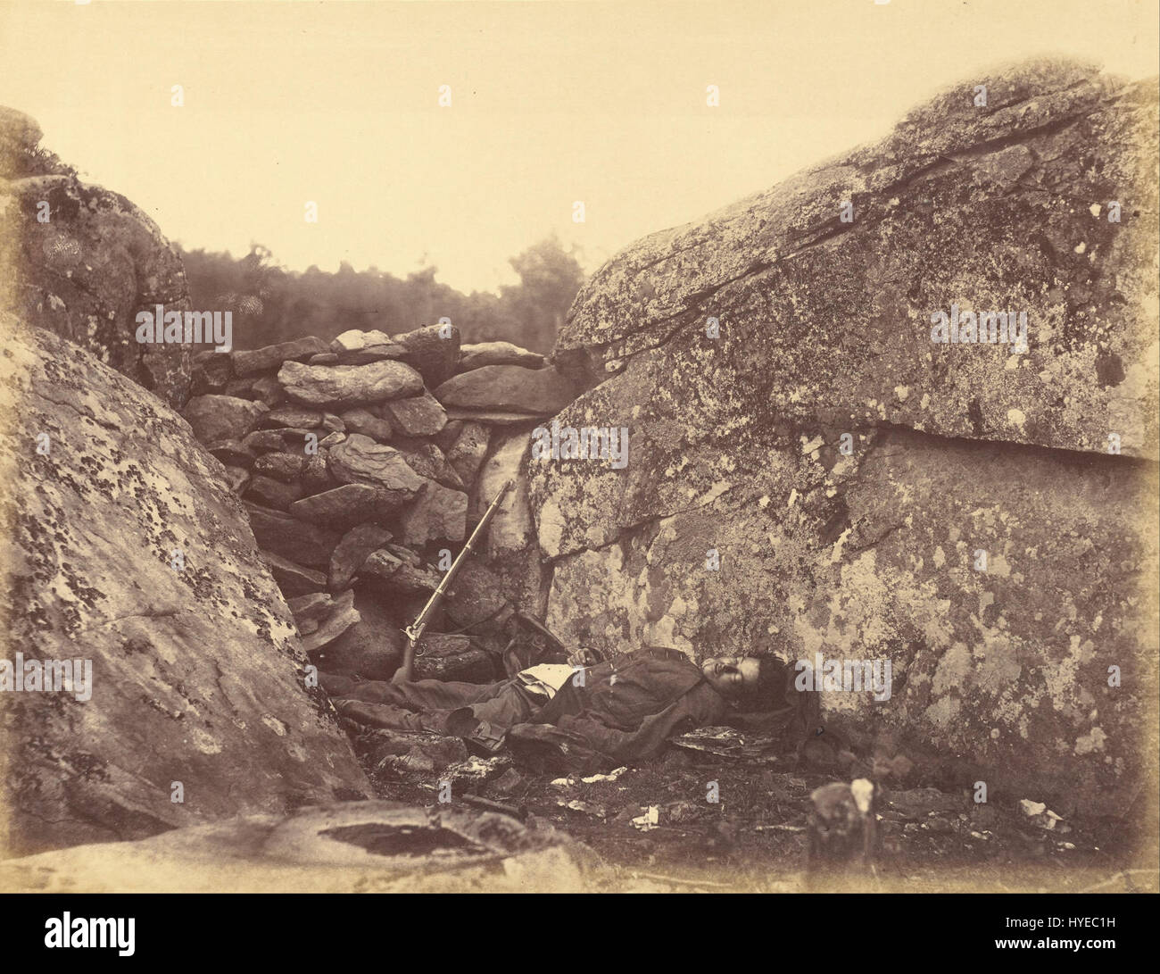 'Home of a Rebel Sharpshooter' d'Alexander Gardner est une célèbre photographie de la guerre de Sécession prise en 1863 à Gettysburg. Il représente un tireur d'élite confédéré allongé mort à côté d'un arbre, symbolisant les dures réalités de la guerre pendant la bataille de Gettysburg. La photographie de Gardner est remarquable pour son réalisme brutal et la documentation du coût humain de la guerre de Sécession. Banque D'Images