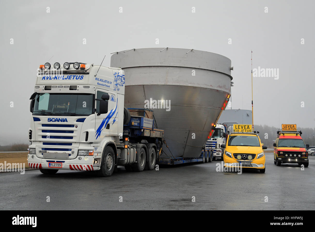 FORSSA, FINLANDE - le 2 avril 2017 : Grande charger transports de max 7,6 m de large objets industriels par deux camions Scania et les voitures d'escorte faites une pause à un truc Banque D'Images